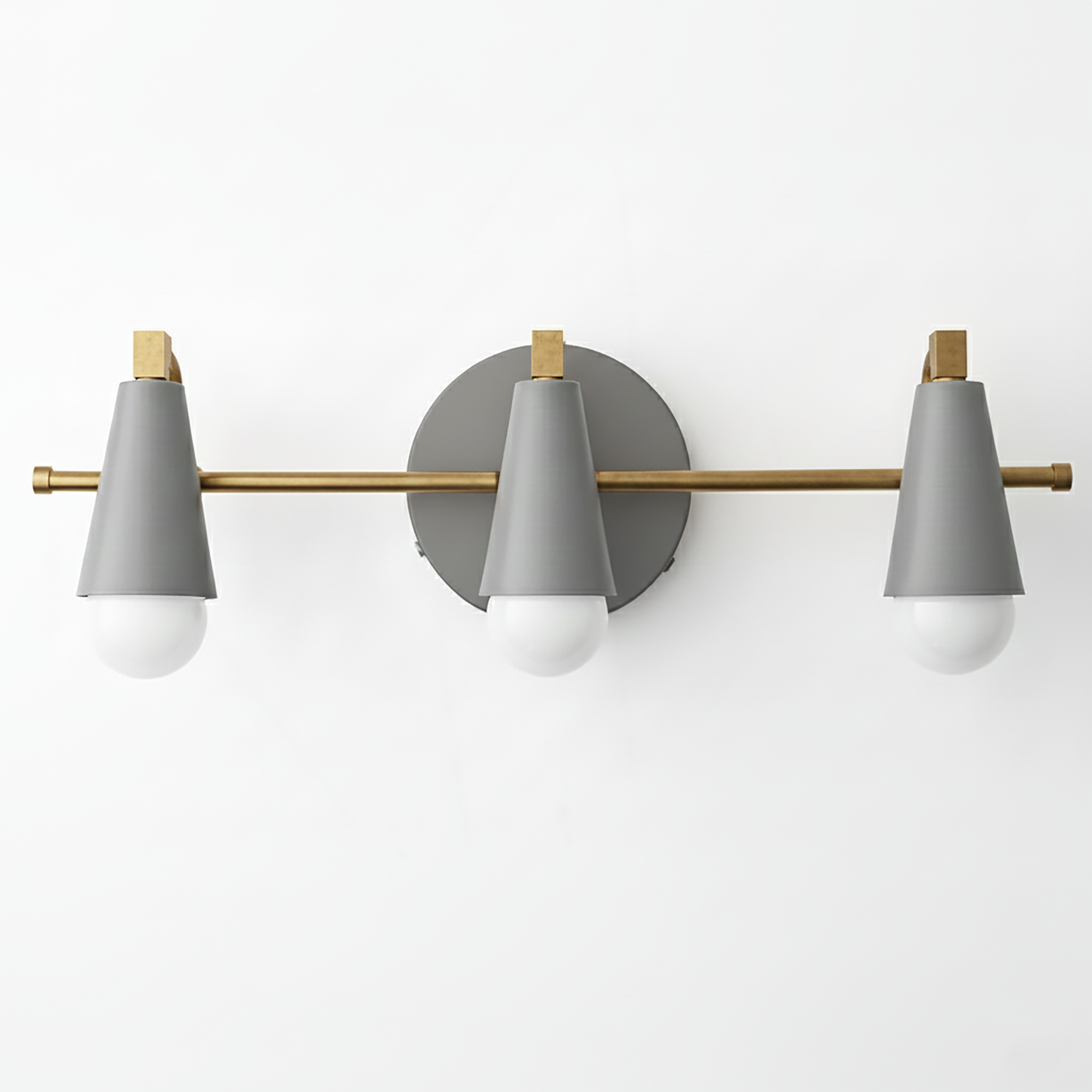 Three-light vanity fixture with matte gray conical shades, brass horizontal bar, and round gray wall mount. - VANITY LIGHT MODEL NO. 8084