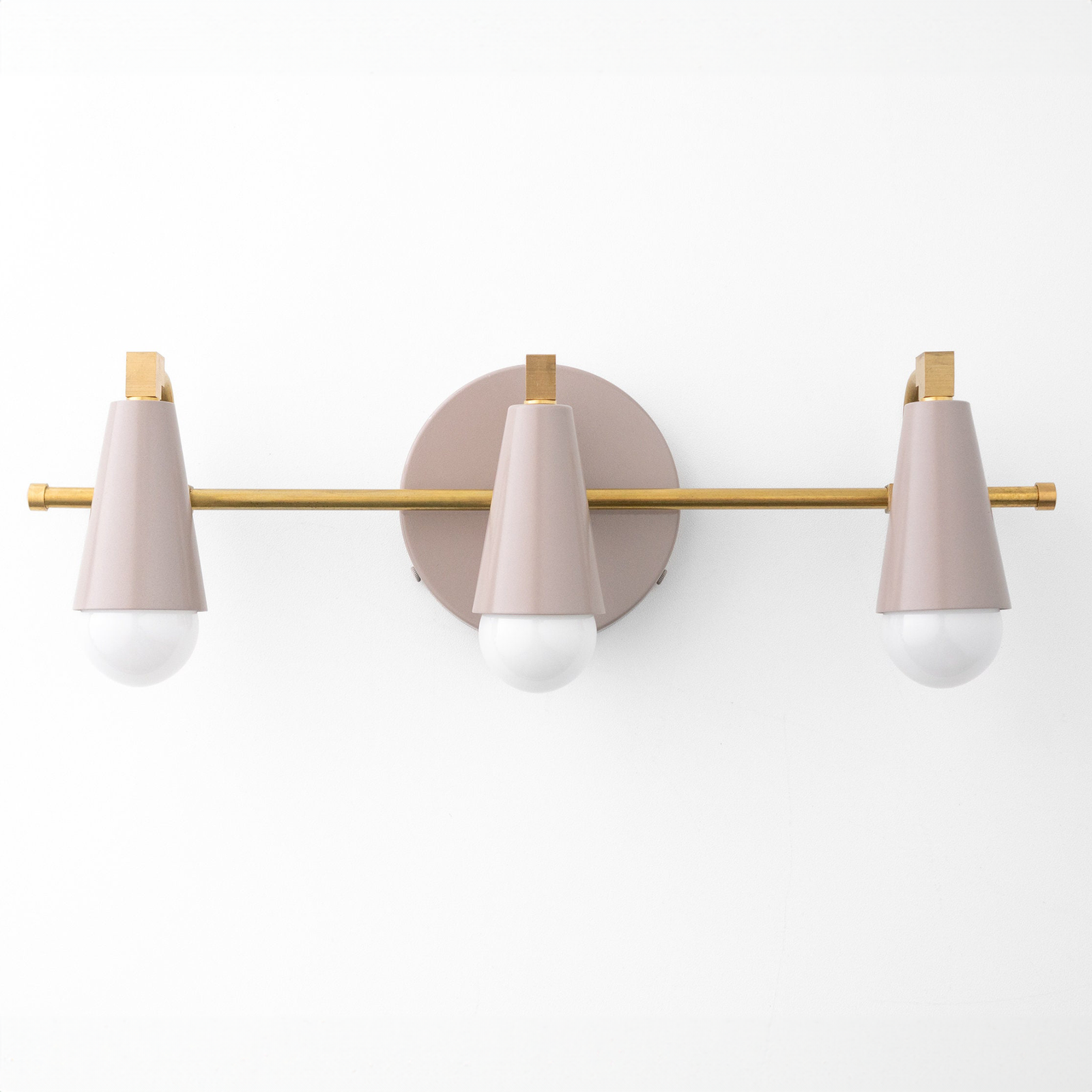 Three-light vanity fixture with matte pink conical shades and brass horizontal bar mounting on round pink base. - VANITY LIGHT MODEL NO. 8084