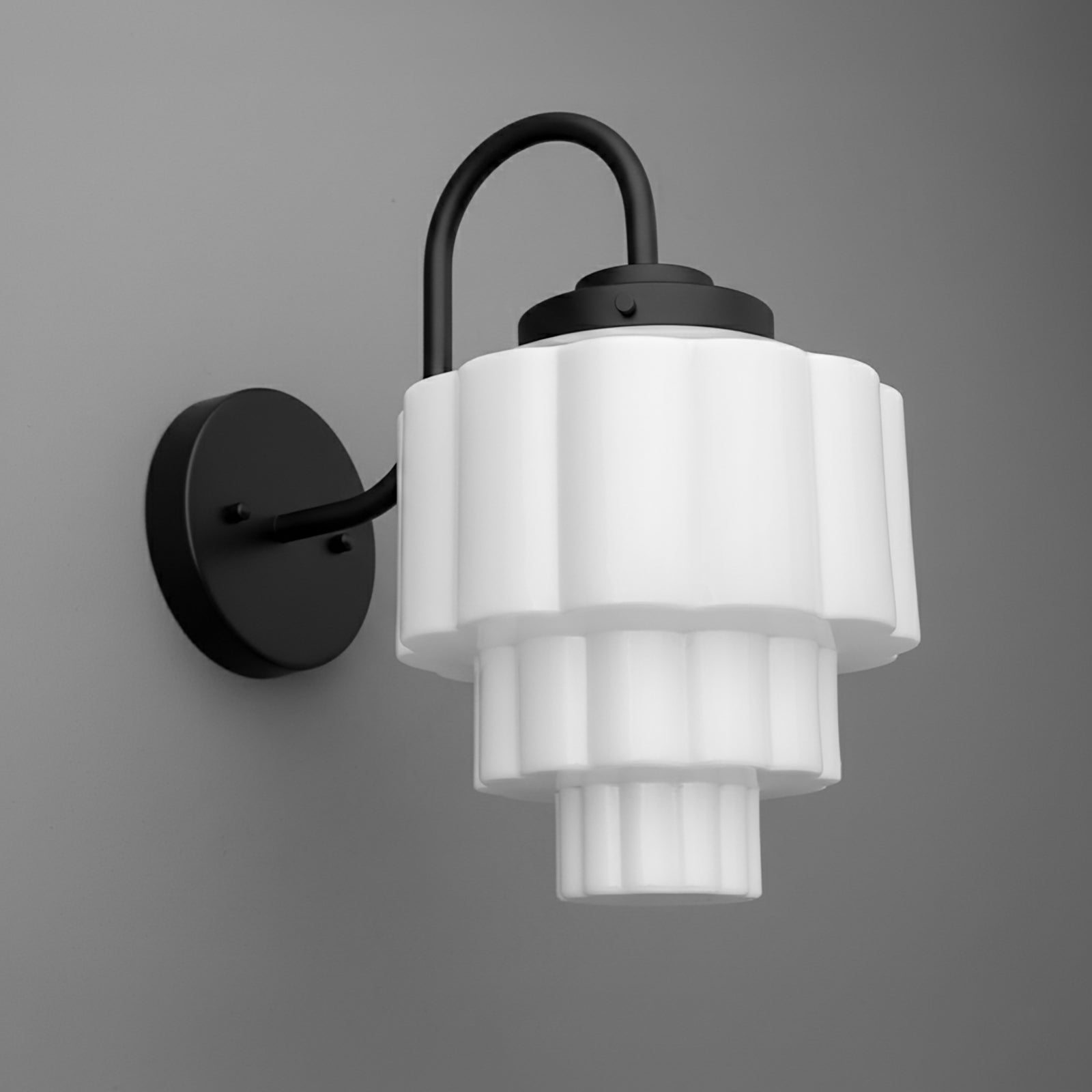 Black metal wall sconce with tiered white frosted glass shade in geometric scalloped design. - SCONCE MODEL NO. 1095