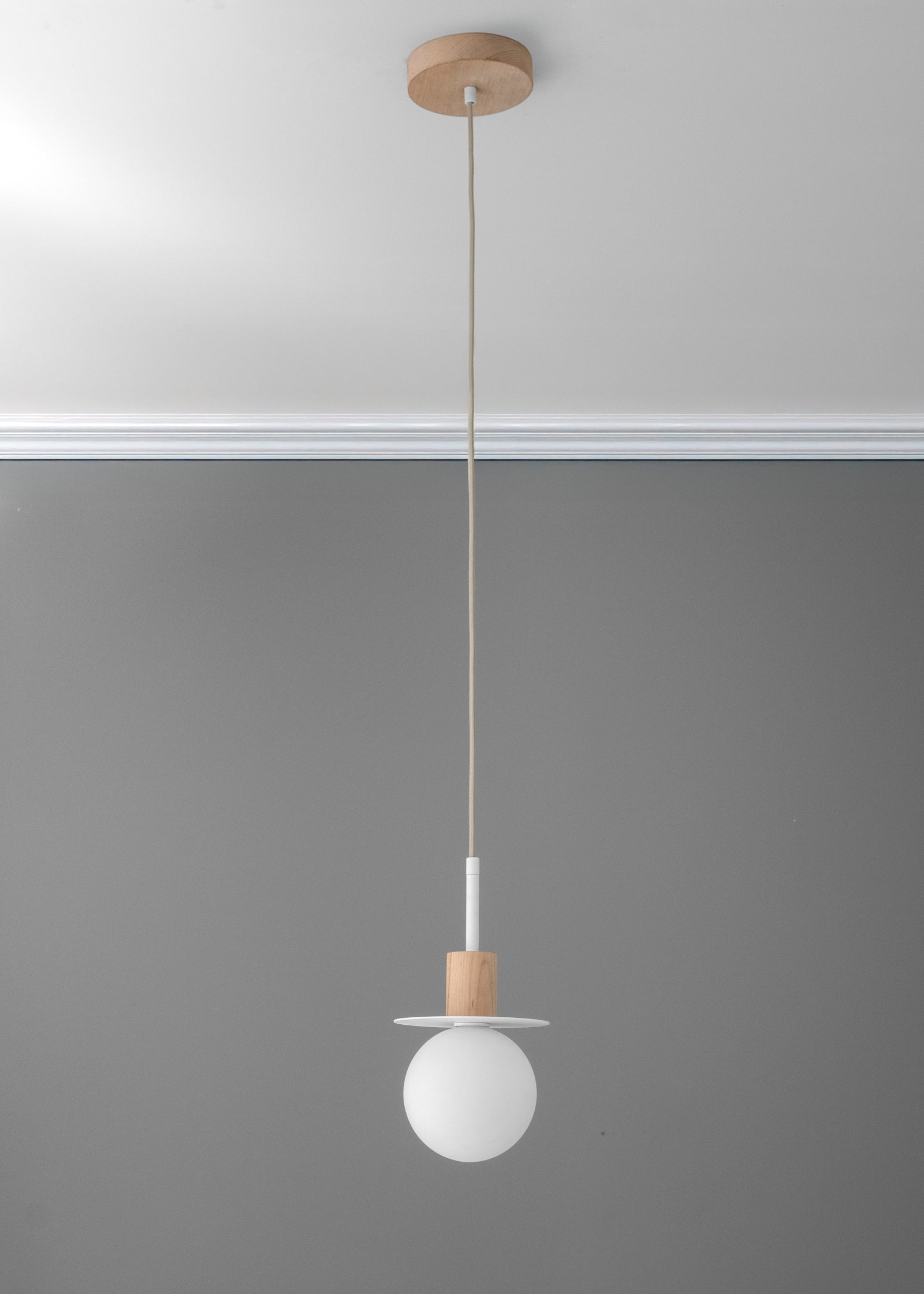 Minimal pendant light with white globe shade and tan wood accent suspended by a thin cord. - PENDANT MODEL NO. 6198