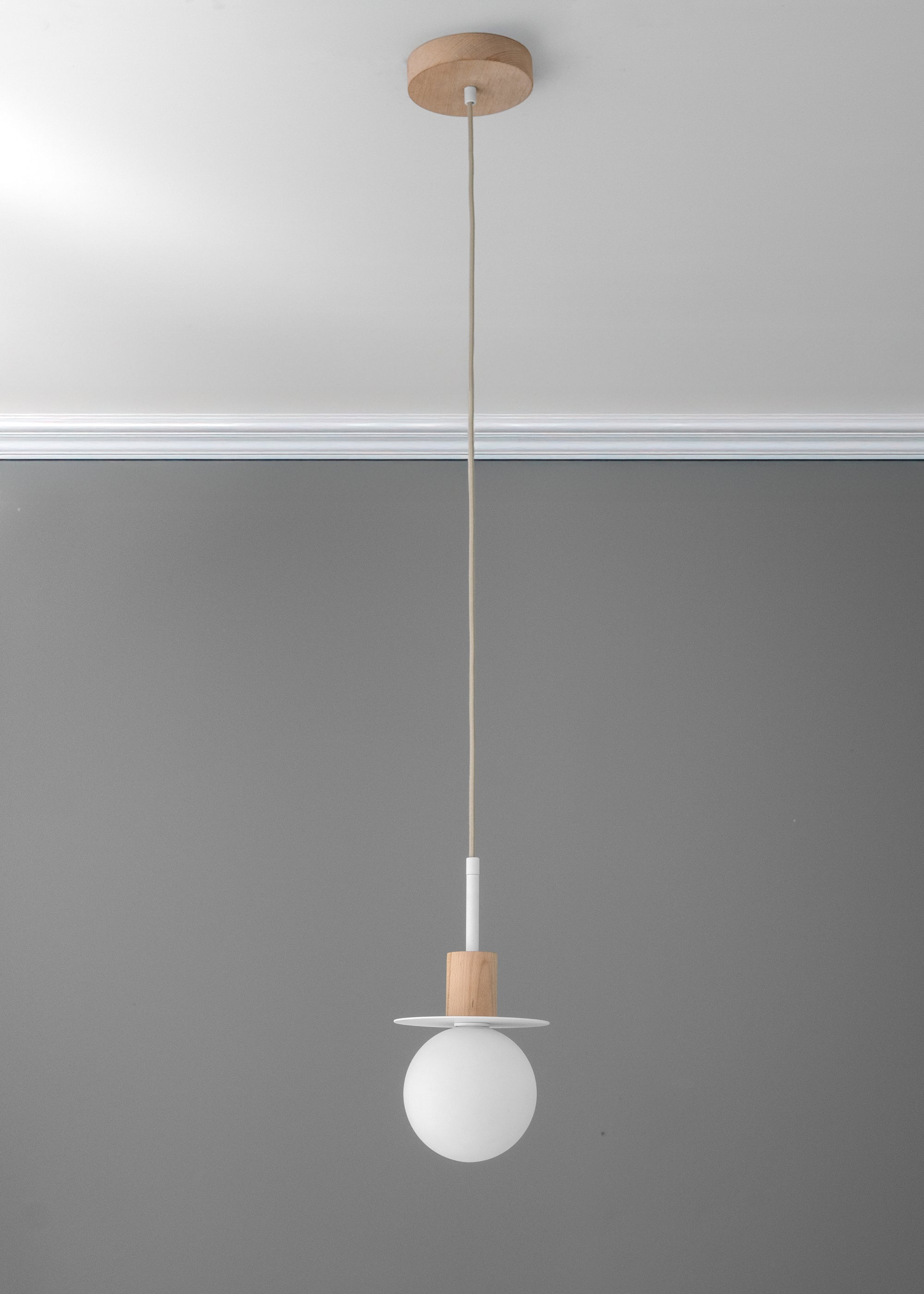 Minimal pendant light with white globe shade and tan wood accent suspended by a thin cord. - PENDANT MODEL NO. 6198