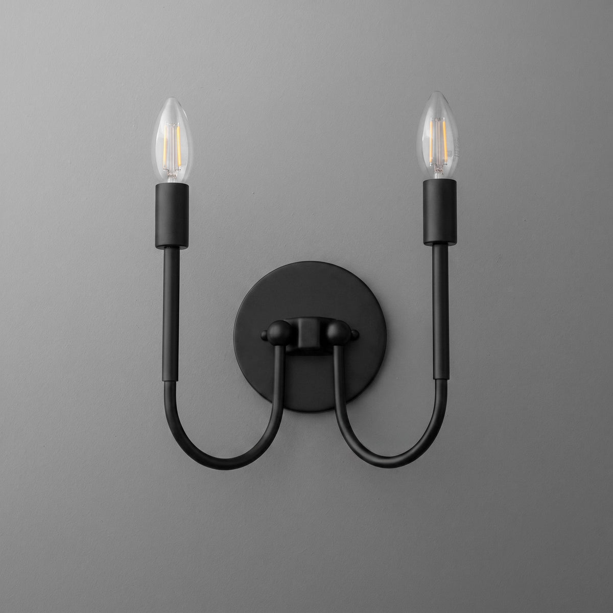 Matte black metal two-bulb wall sconce with curved arms and round backplate. - SCONCE MODEL NO. 4122