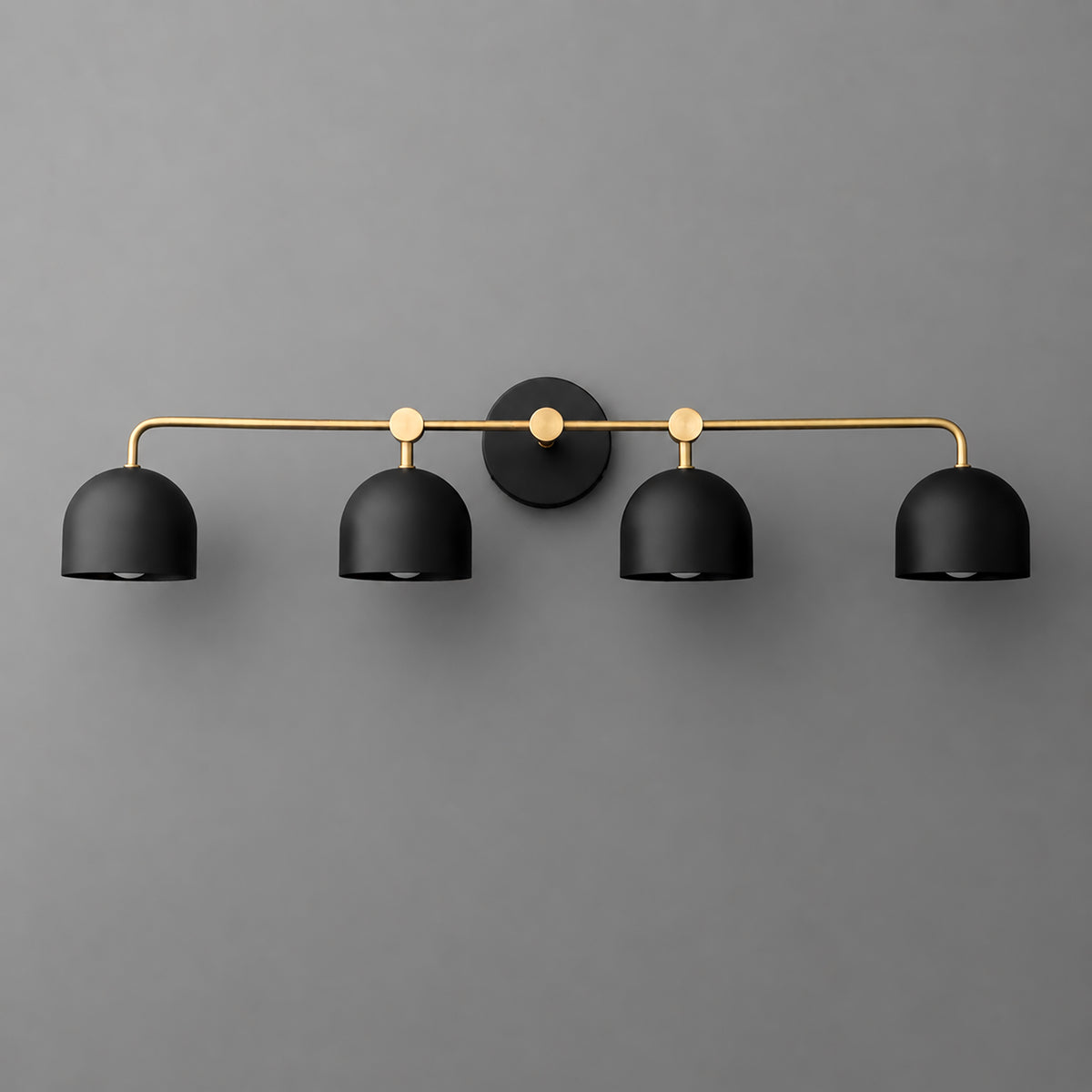 Four-light vanity light in Raw or Sealed Brass with Black dome shades and a matching Black wall plate. - VANITY LIGHT MODEL NO. 1124