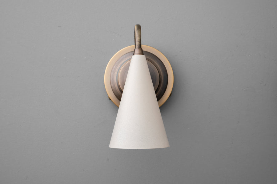 Antique brass up/down sconce with smooth cream conical shade on gray wall. - Sconce Model No. 6790