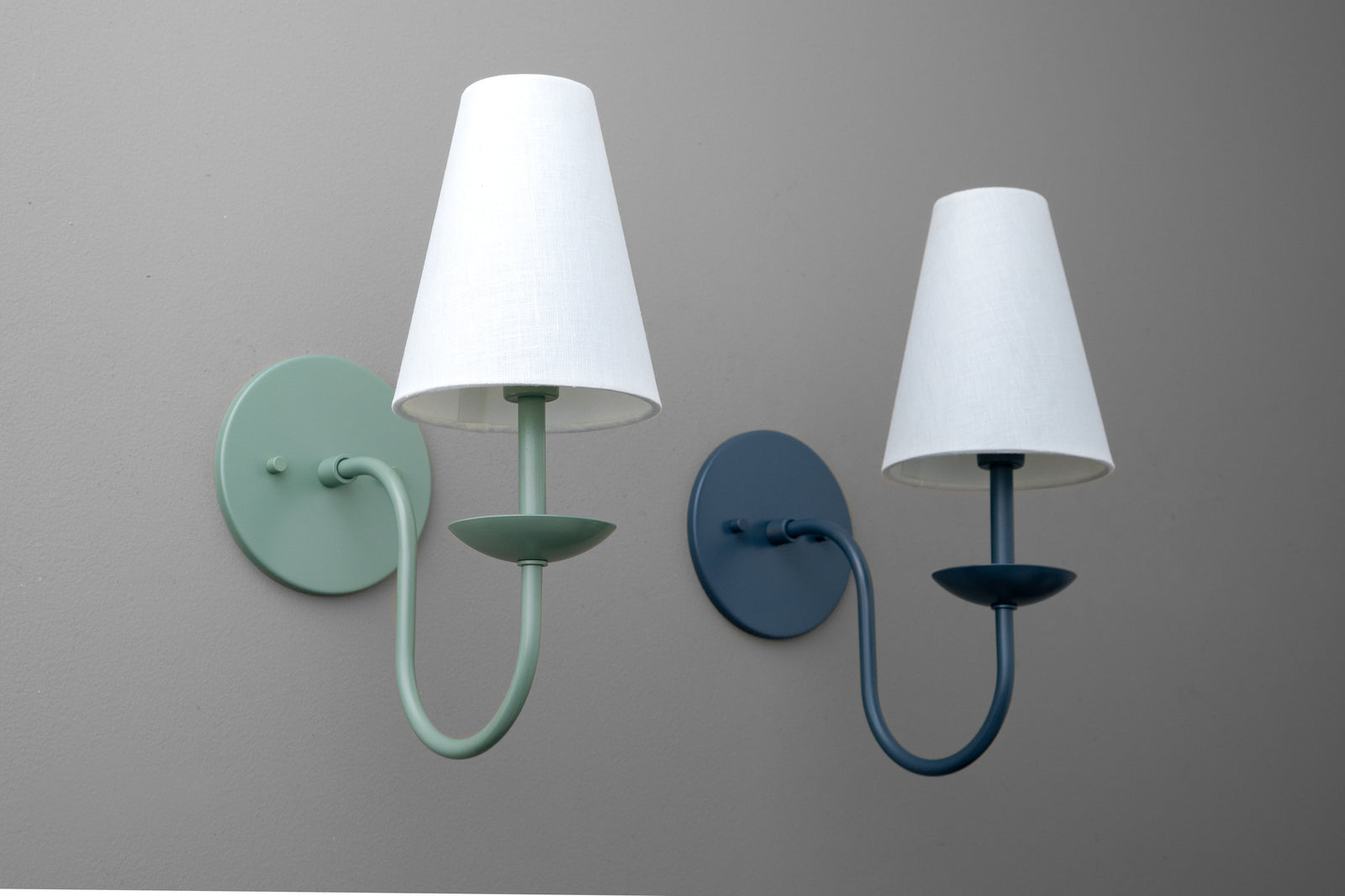 Pair of wall sconces with cone-shaped white shades in matte teal and navy blue metal finishes. - SCONCE MODEL NO. 7085