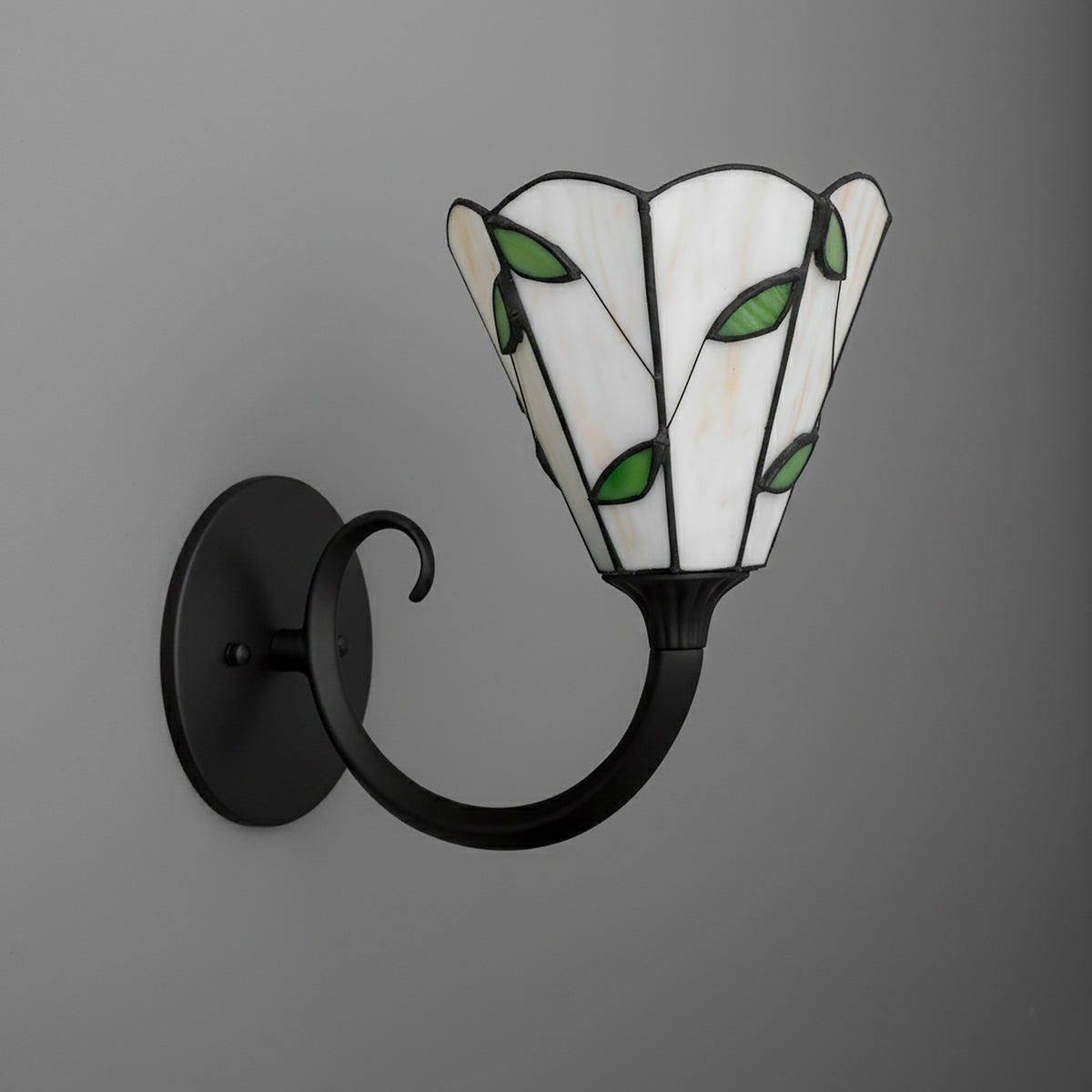 Black metal 1-bulb wall sconce with curved arm and flower-shaped stained glass shade featuring white panels and green leaf. - SCONCE MODEL NO. 1056