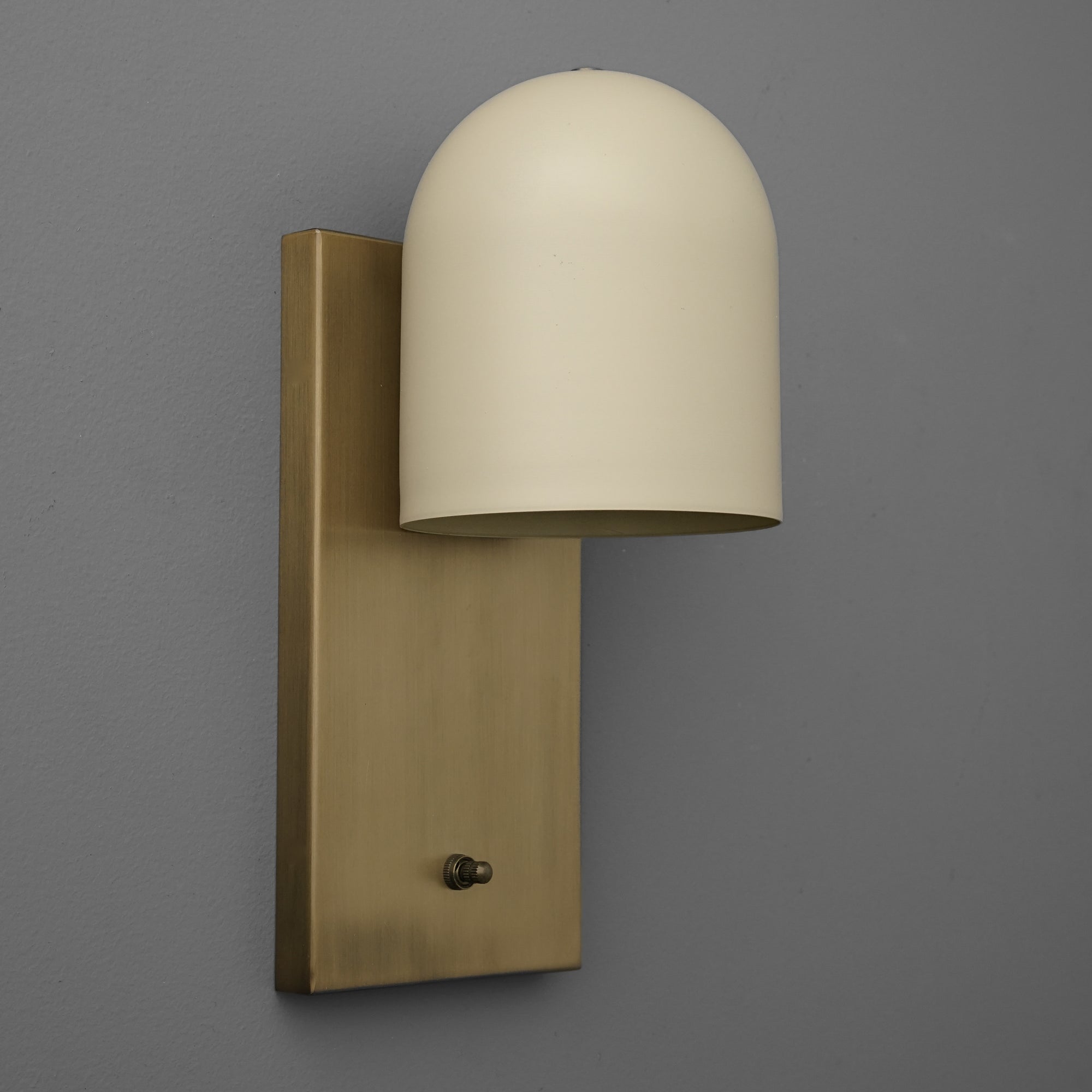 Antique brass wall sconce with smooth cream dome-shaped shade and rectangular backplate. - SCONCE MODEL NO. 6029