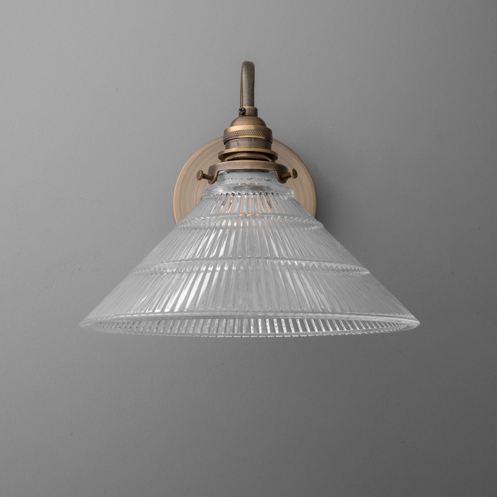 Antique brass wall sconce with clear ribbed glass cone shade and single bulb fixture. - SCONCE MODEL NO. 4703