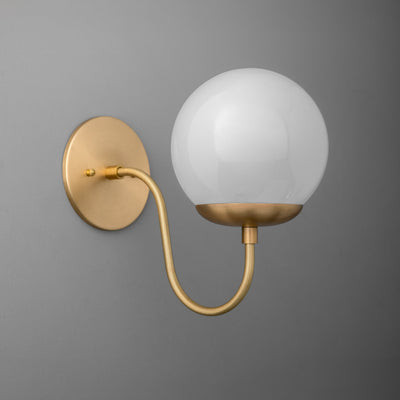 Wall sconce with matte brass finish, curved arm, and frosted glass globe shade. - SCONCE MODEL NO. 3849