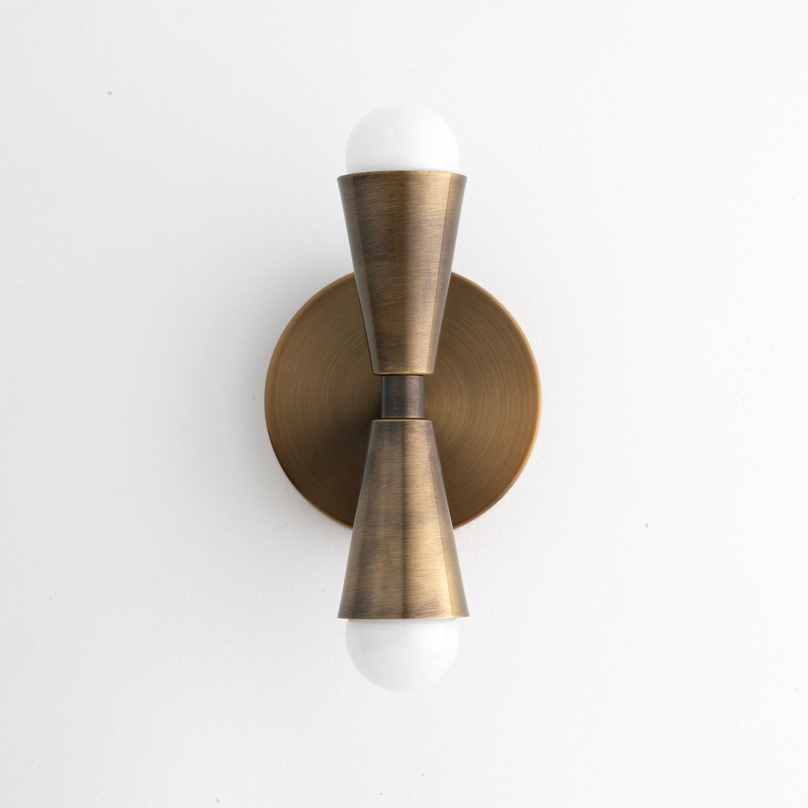 Art Deco bronze-finished metal sconce with conical fixtures and exposed white bulbs top and bottom. - SCONCE MODEL NO. 4717
