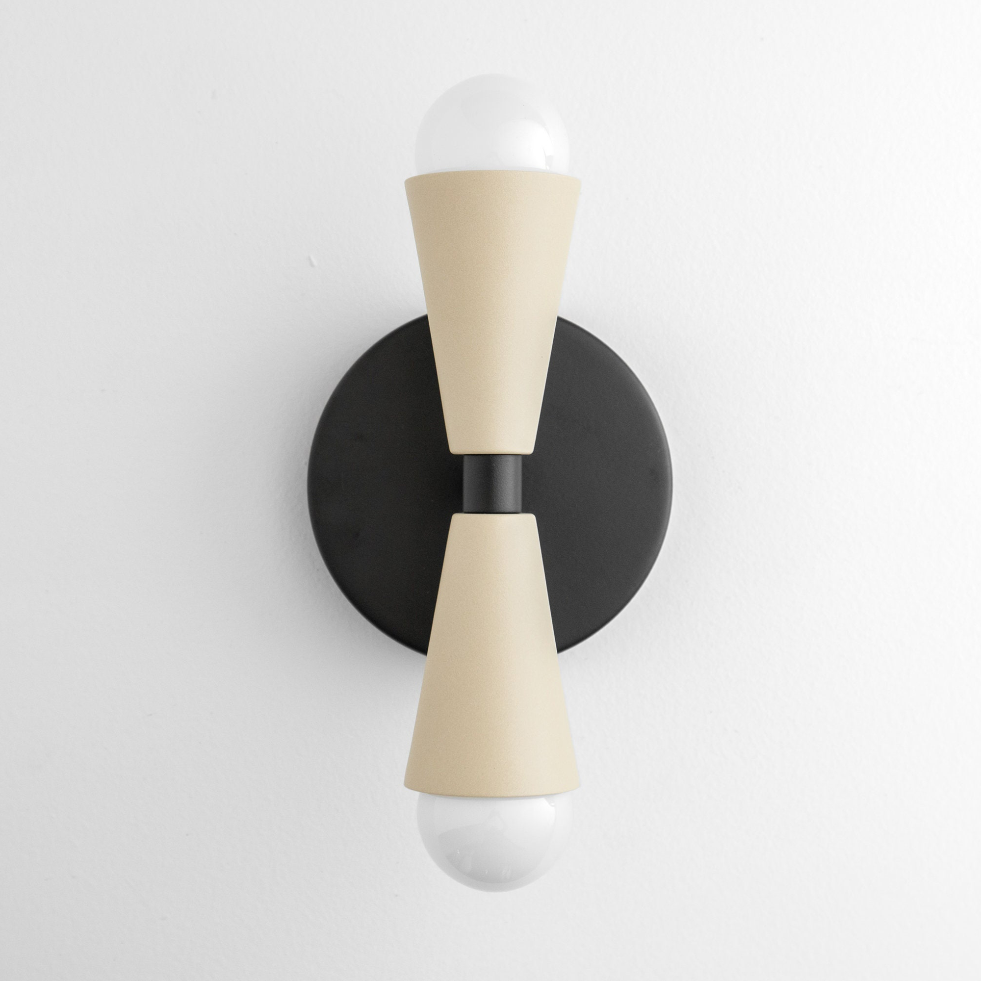 Modern up/down wall sconce with matte black round base and cream tapered shades covering bulbs. - SCONCE MODEL NO. 4717