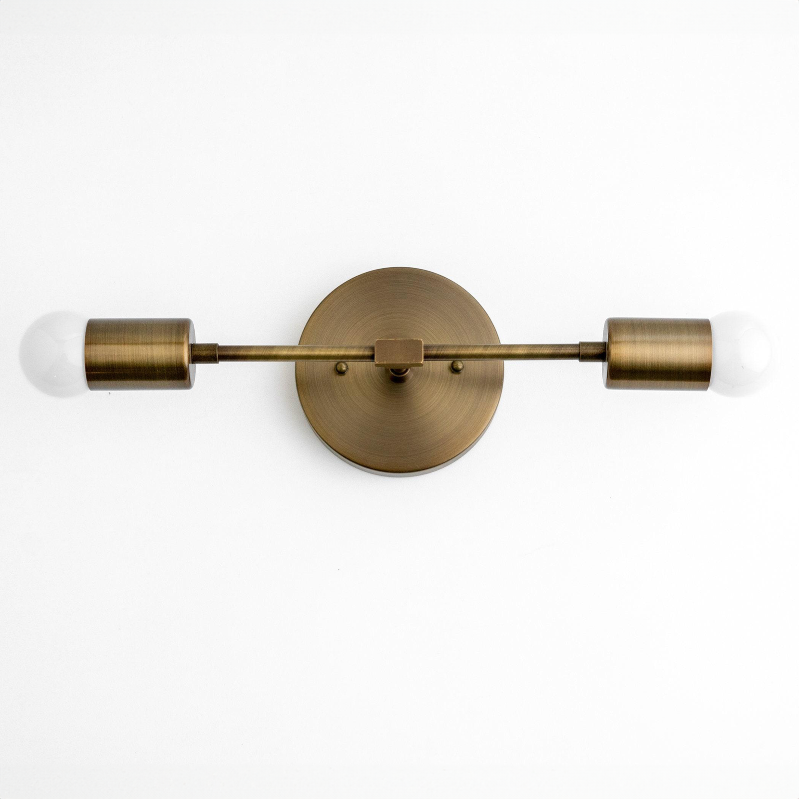 Mid-century modern raw brass two-bulb vanity light with exposed bulbs and round wall mount. - VANITY LIGHT MODEL NO. 5563