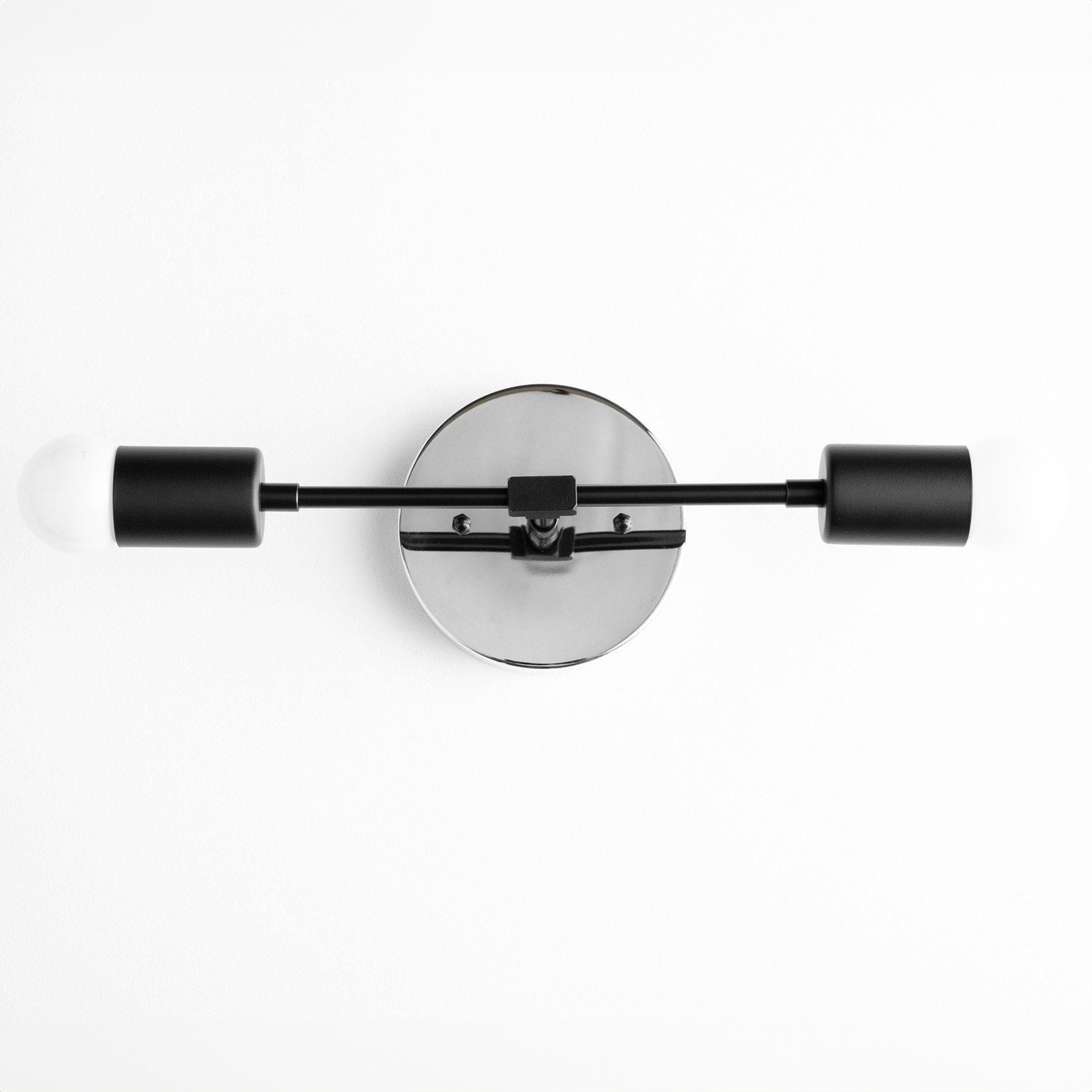 Mid-century modern black two-bulb vanity light with round backplate and cylindrical shades. - VANITY LIGHT MODEL NO. 5563