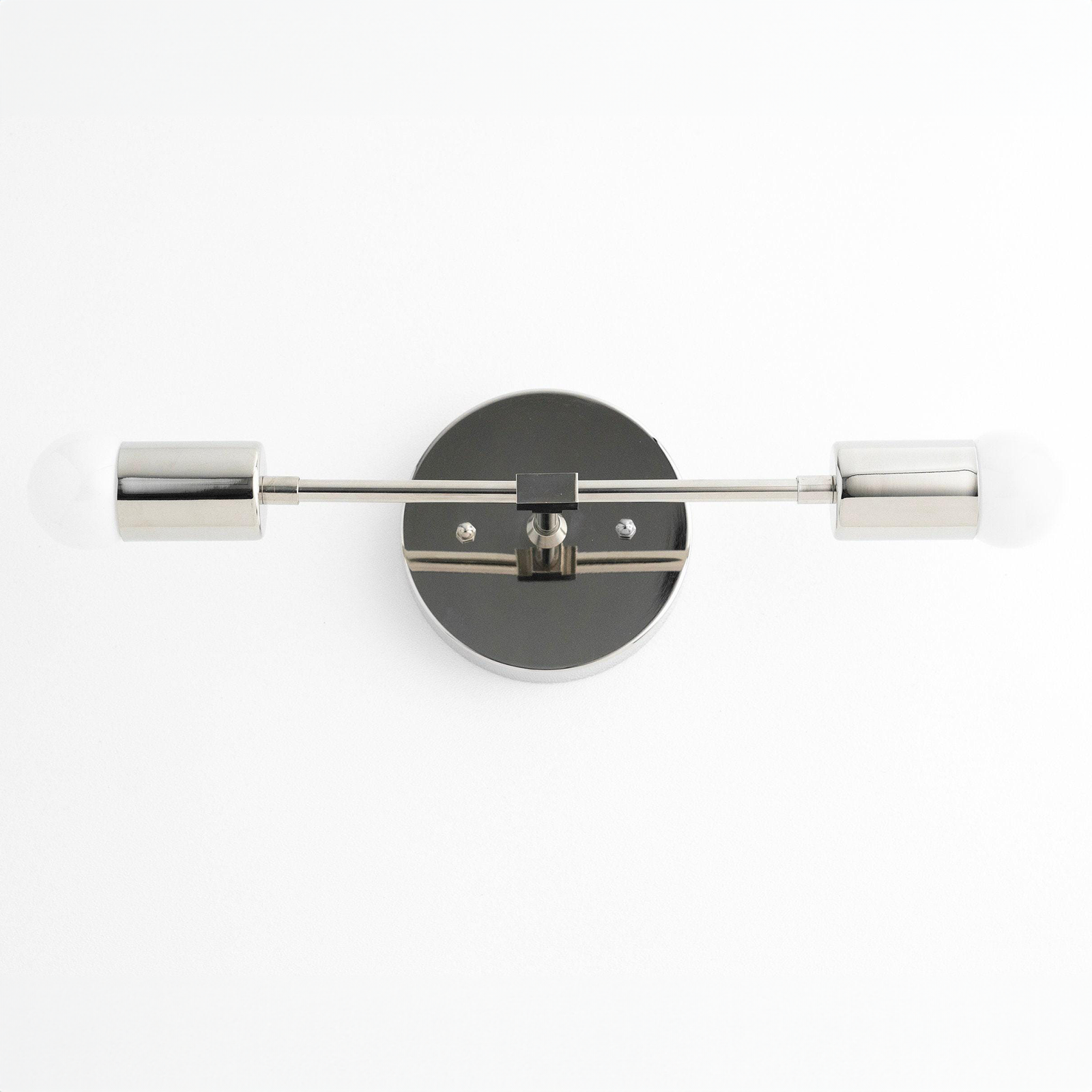 Mid-century modern two-bulb vanity light with black circular base and polished nickel cylindrical shades. - VANITY LIGHT MODEL NO. 5563