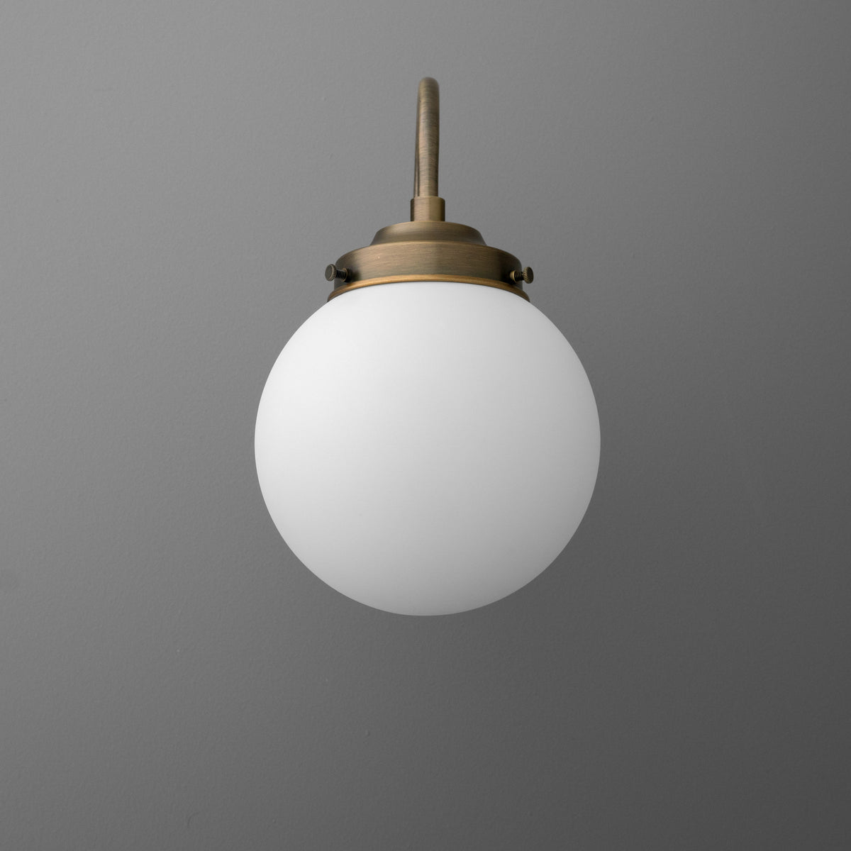 Antique brass wall sconce with frosted white glass globe shade and round mounting base. - SCONCE MODEL NO. 1886