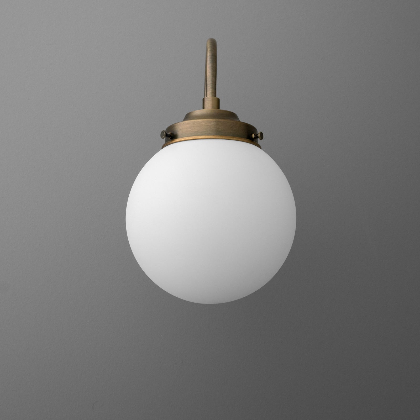 Antique brass wall sconce with frosted white glass globe shade and round mounting base. - SCONCE MODEL NO. 1886