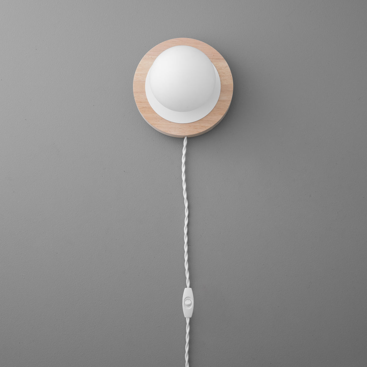 Wall sconce with round white frosted globe and natural wood backplate, white twisted fabric cord with inline switch. - SCONCE MODEL NO. 6154
