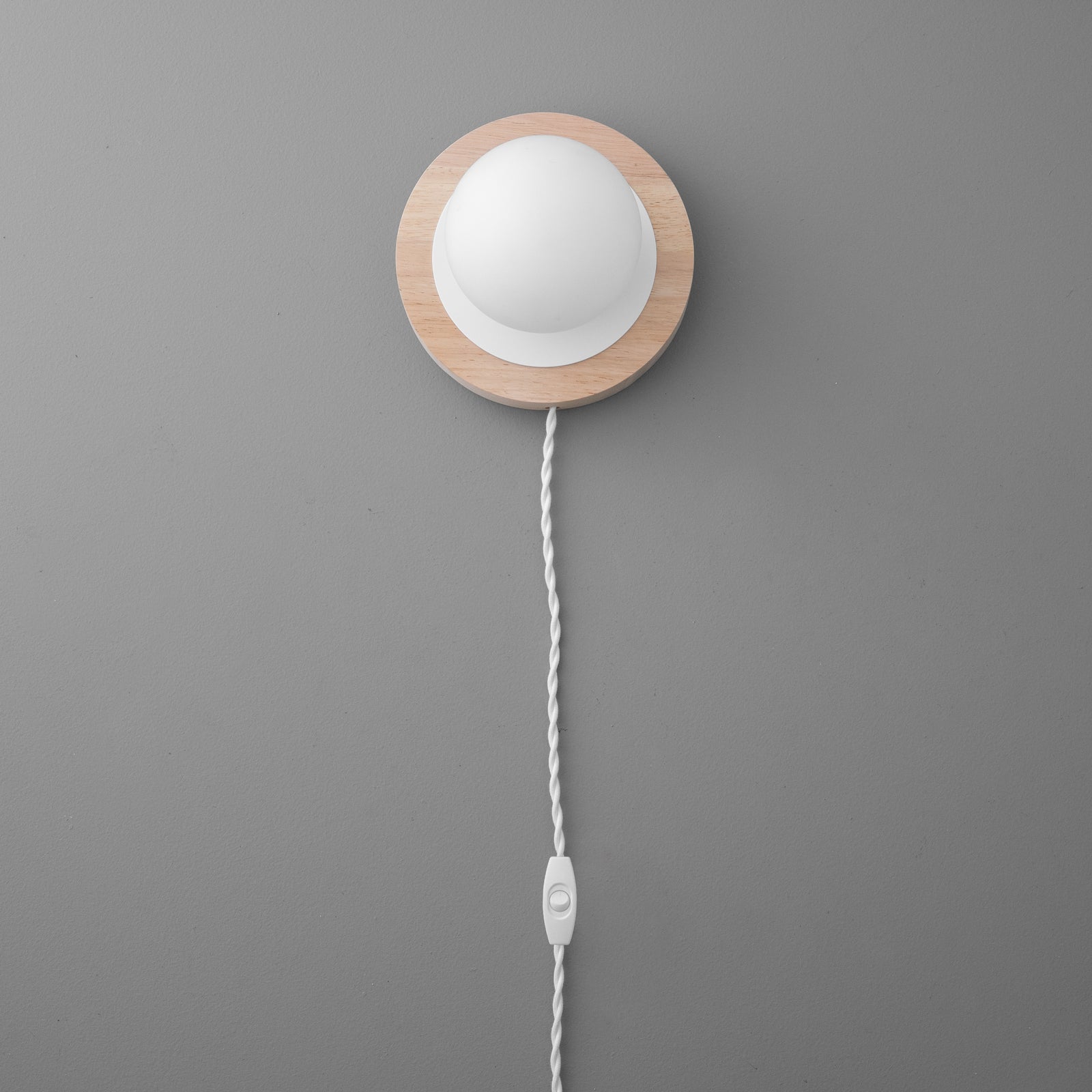 Wall sconce with round white frosted globe and natural wood backplate, white twisted fabric cord with inline switch. - SCONCE MODEL NO. 6154