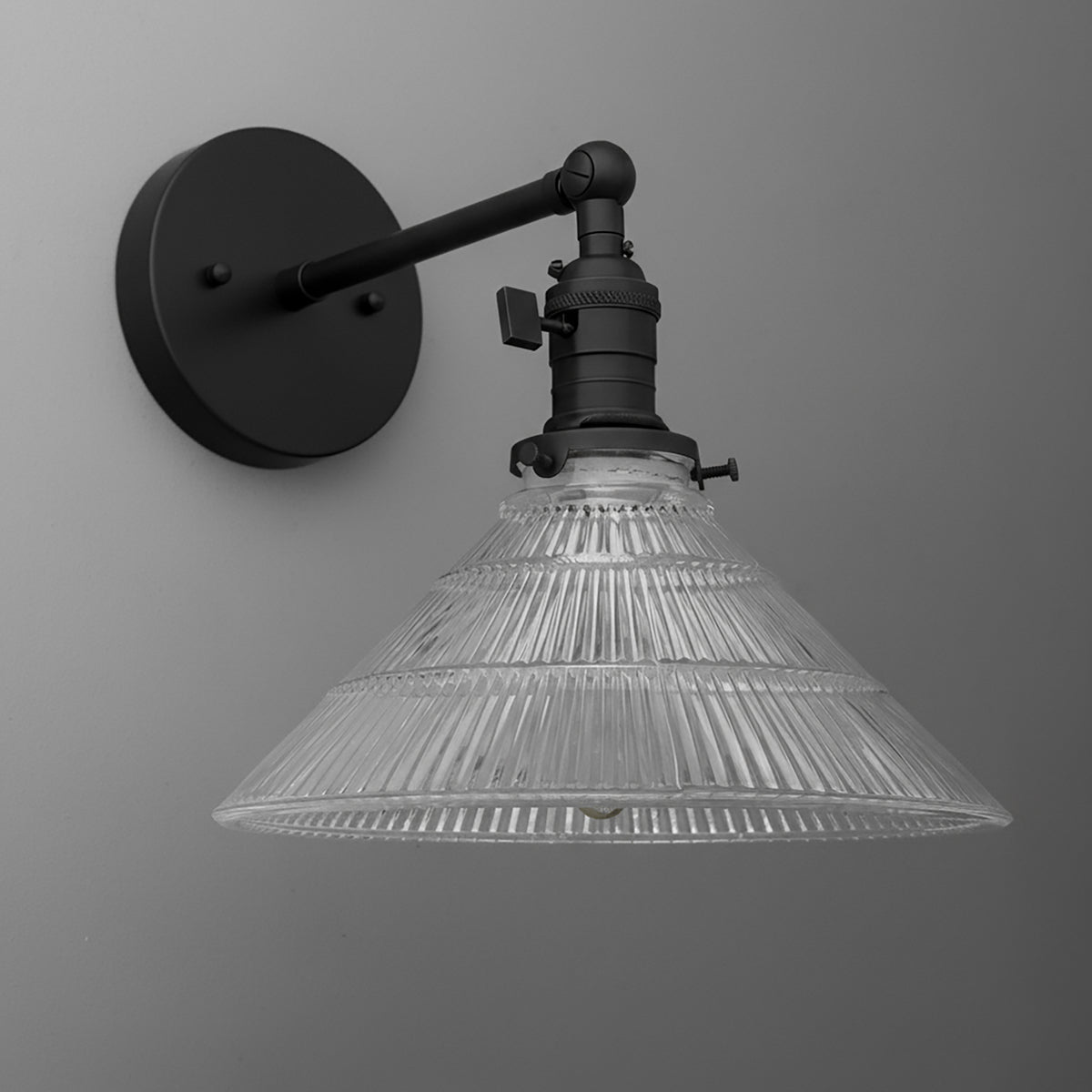 Black metal wall sconce with clear ribbed glass conical shade and adjustable arm. - SCONCE MODEL NO. 3170