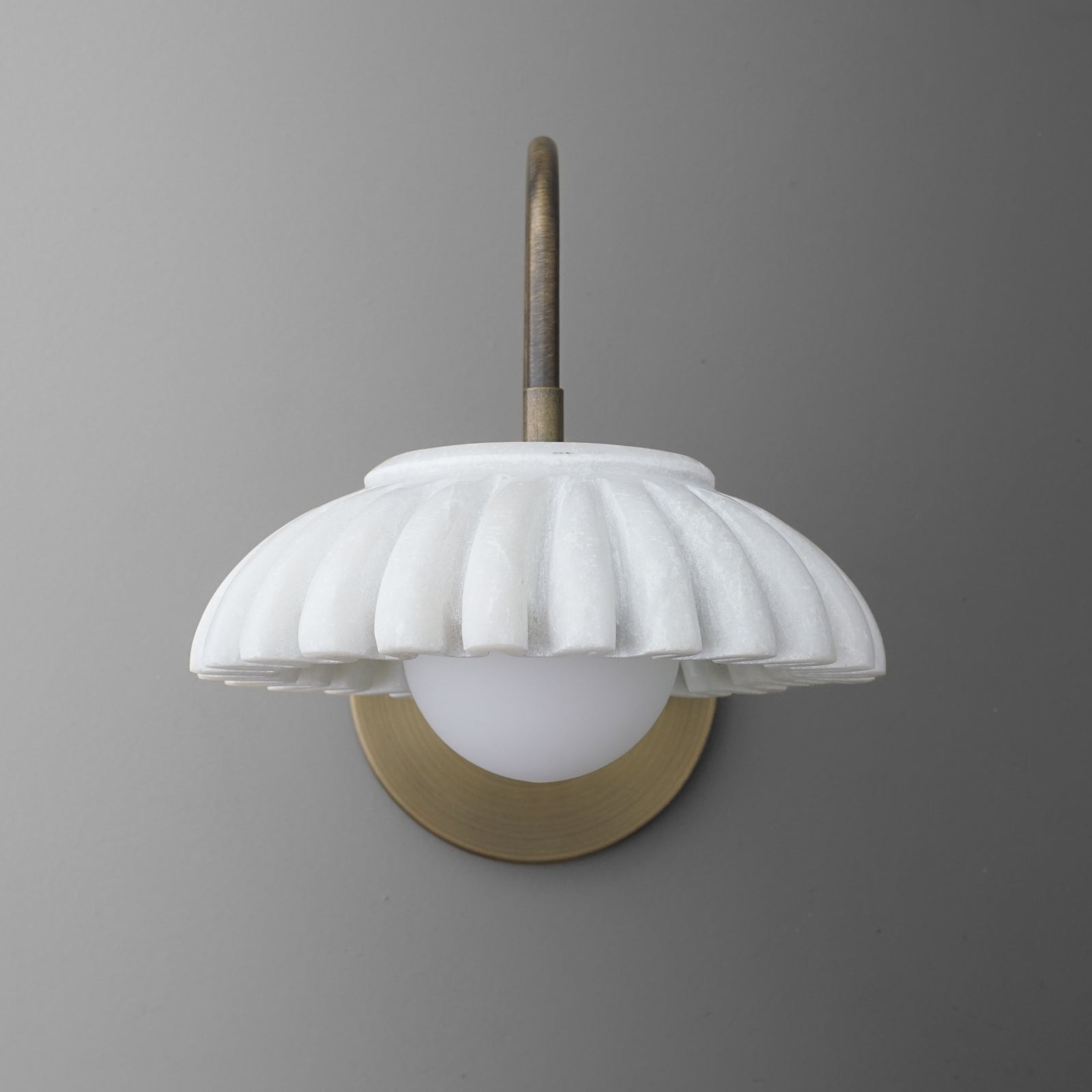 Wall sconce with fluted white glass shade and antique brass curved arm and backplate. - SCONCE MODEL NO. 2782