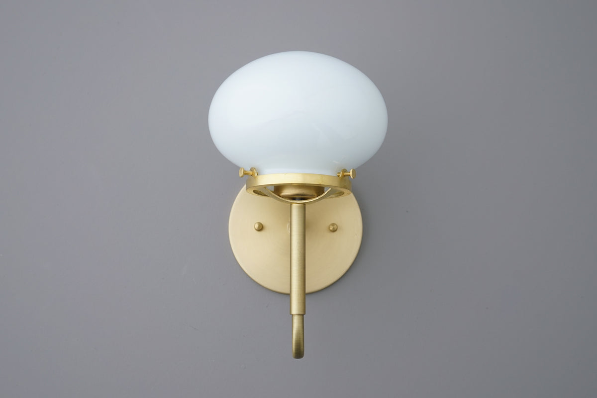 Wall sconce with round white glass shade and brushed brass metal base and arm. - SCONCE MODEL NO. 9452