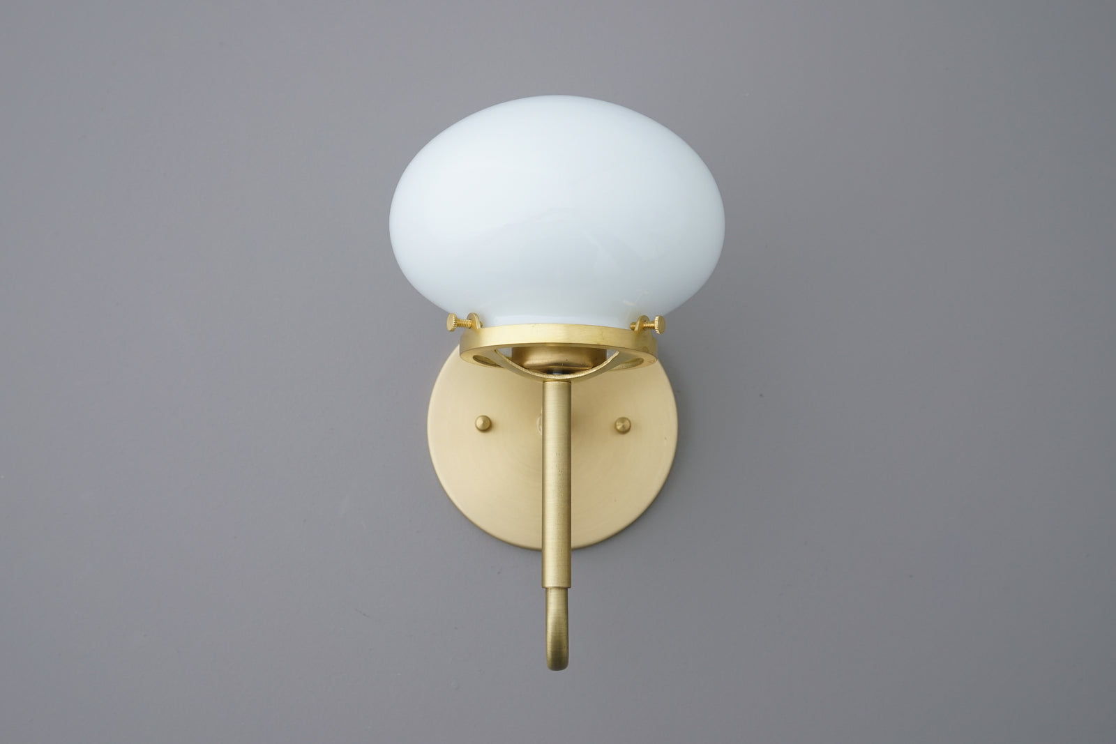 Wall sconce with round white glass shade and brushed brass metal base and arm. - SCONCE MODEL NO. 9452