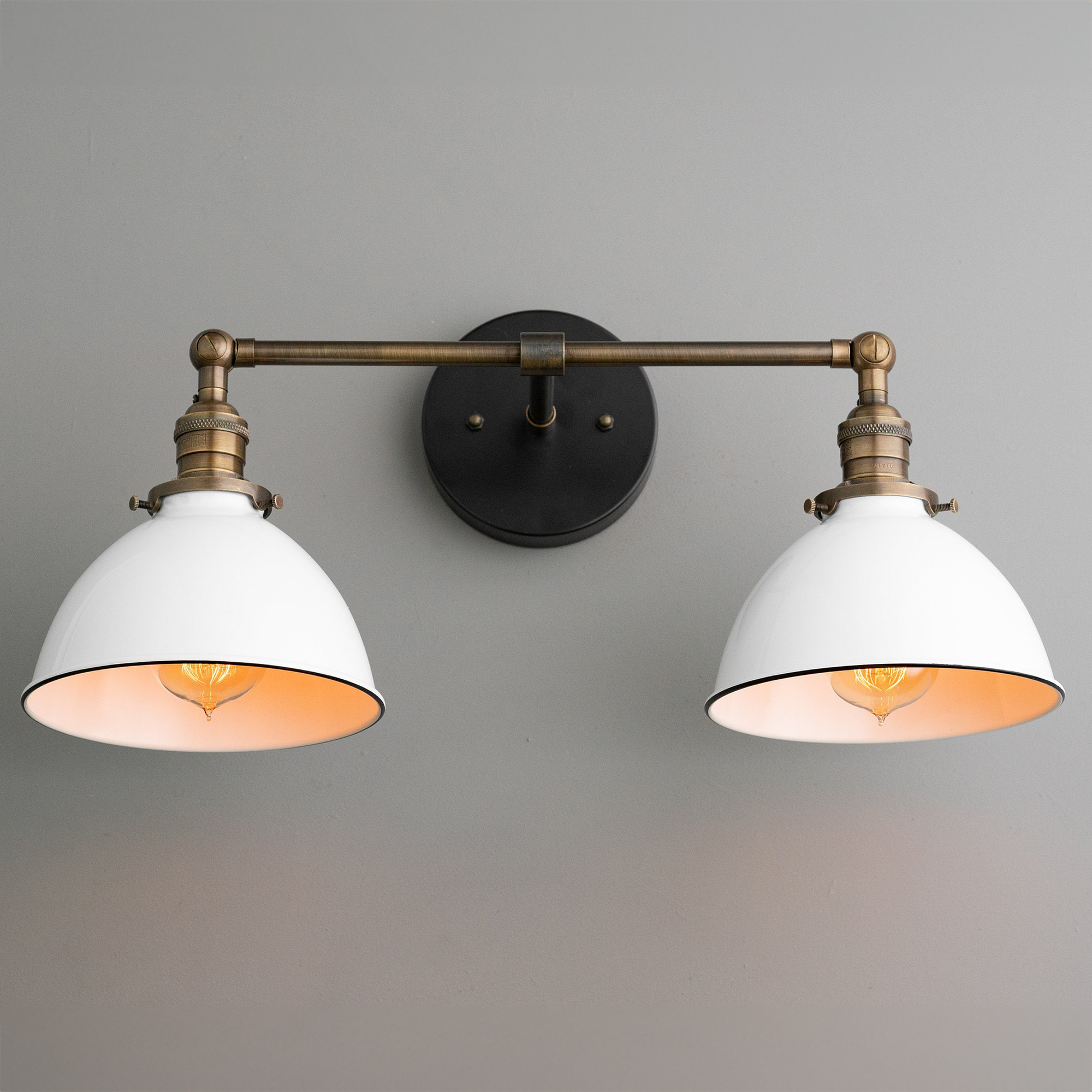 Industrial two-bulb vanity light with white shades and antique brass finish on wall mount. - VANITY LIGHT MODEL NO. 4564