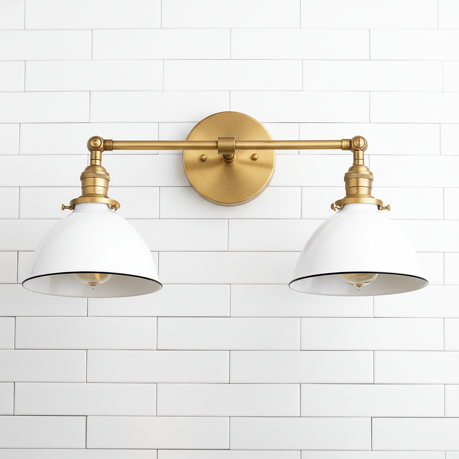 Two-bulb vanity light with antique brass finish and white metal shades mounted on white subway tile wall. - VANITY LIGHT MODEL NO. 4564