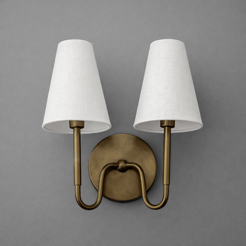 Brushed brass two-bulb wall sconce with curved arms and white tapered fabric shades. - SCONCE MODEL NO. 5265