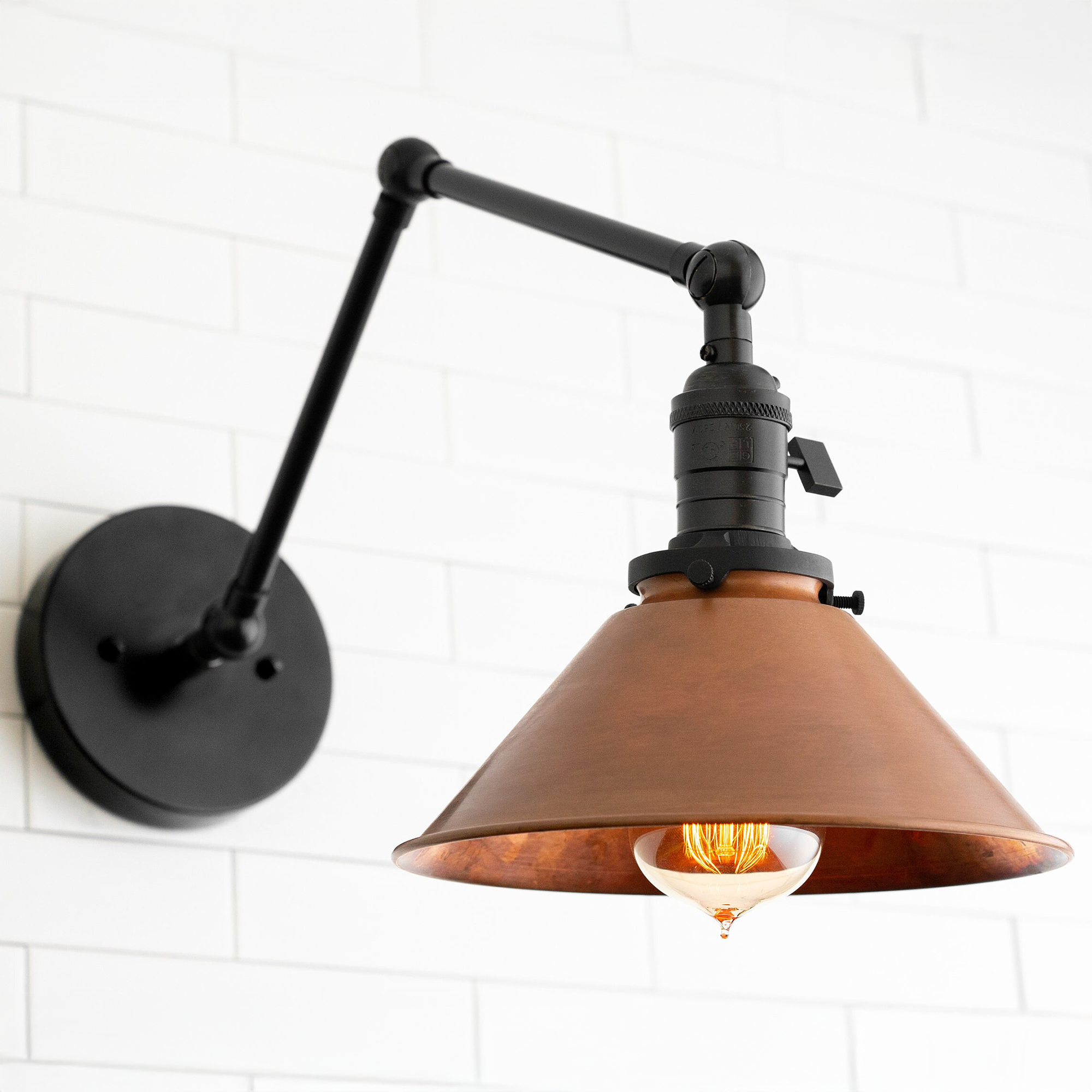 Adjustable black industrial wall sconce with angled arm and copper cone shade. - SCONCE MODEL NO. 6668