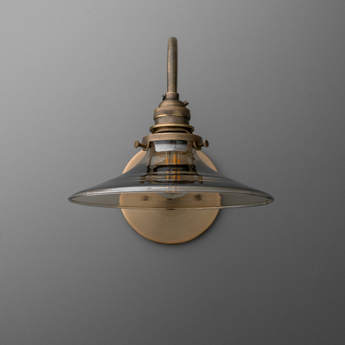 Antique brass wall sconce with clear glass shade and exposed bulb design. - SCONCE MODEL NO. 3901