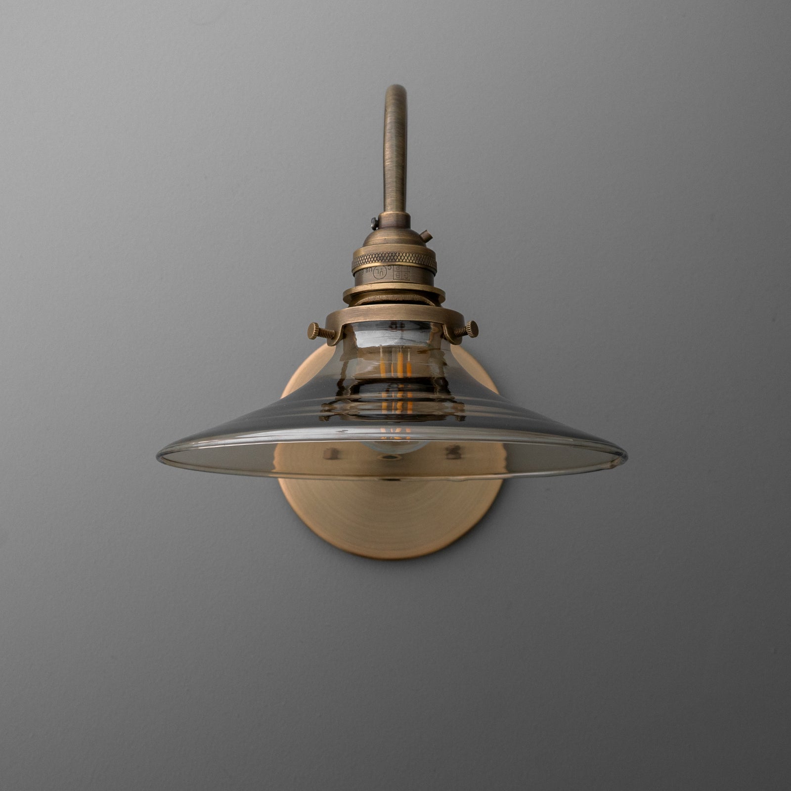 Antique brass wall sconce with clear glass shade and exposed bulb design. - SCONCE MODEL NO. 3901