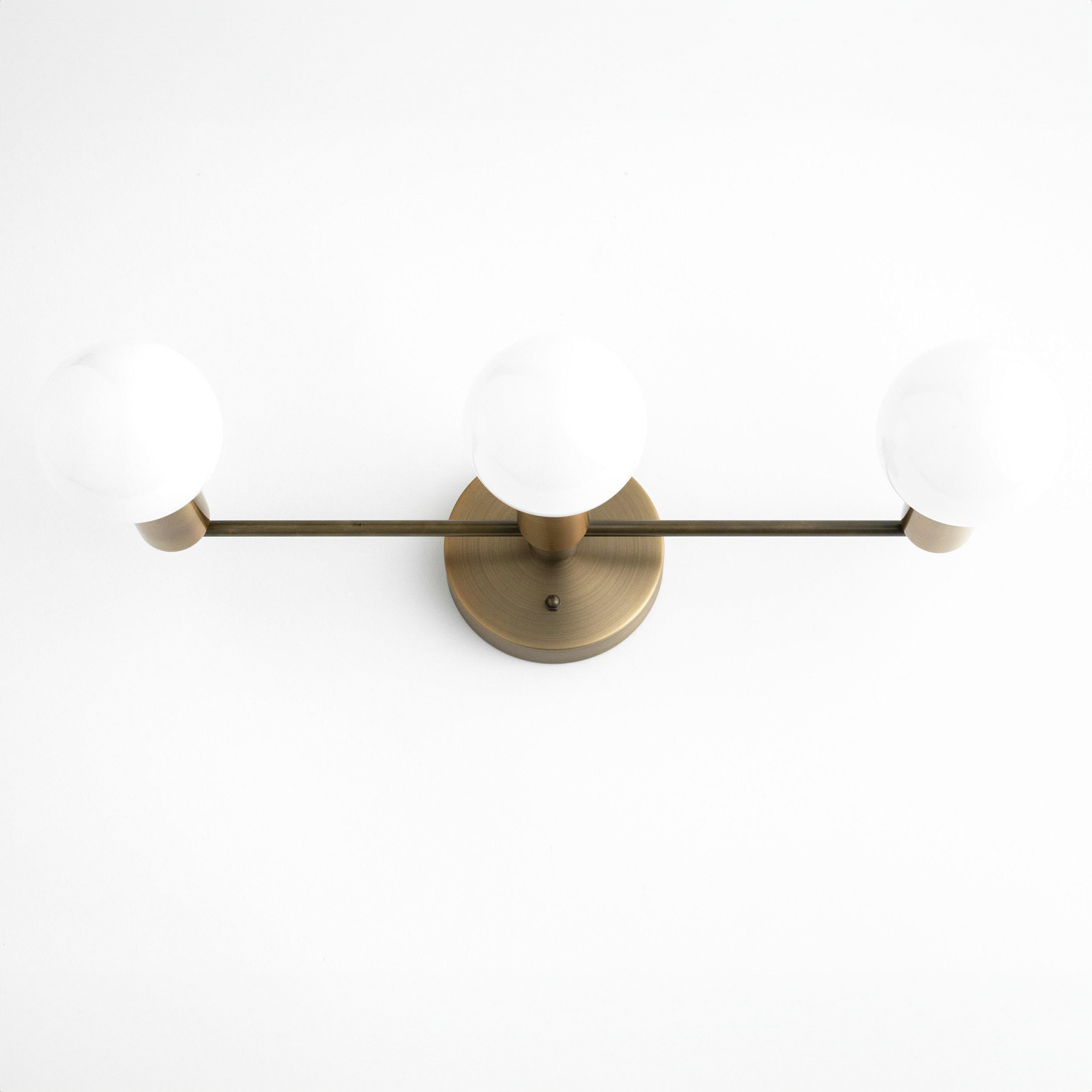Mid-century modern 3-bulb vanity light with raw brass finish and round frosted glass globes. - VANITY LIGHT MODEL NO. 0518