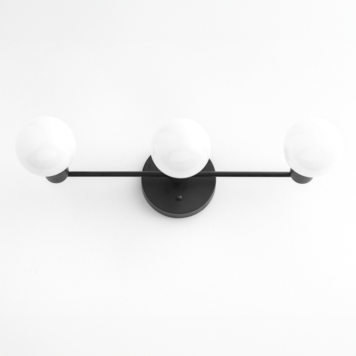Mid-century modern 3-bulb black vanity light with round white glass shades and matte black metal frame. - VANITY LIGHT MODEL NO. 0518