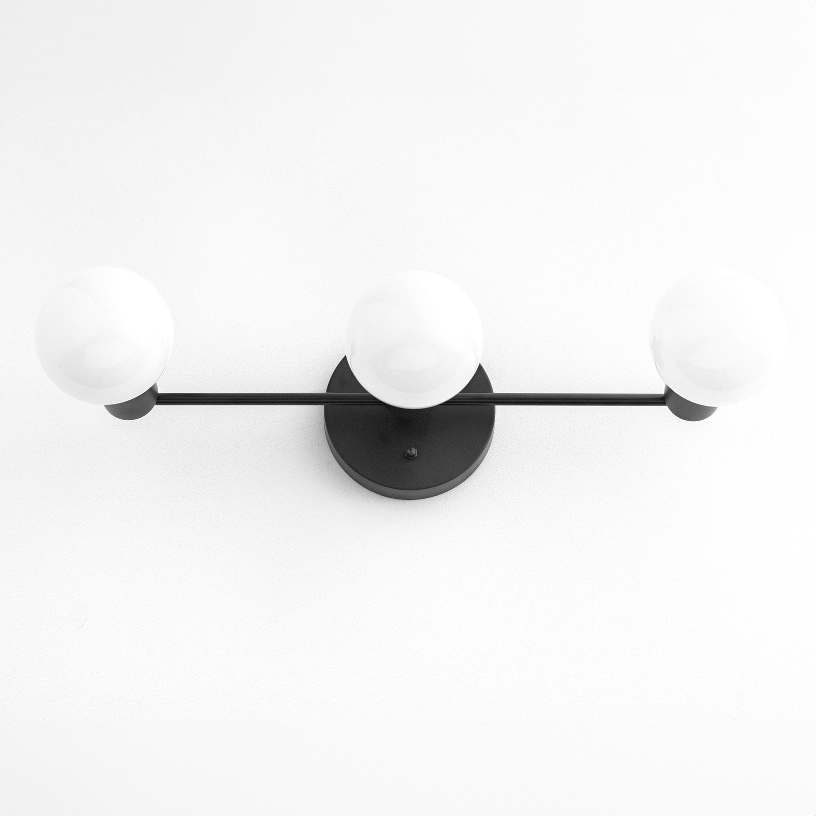 Mid-century modern 3-bulb black vanity light with round white glass shades and matte black metal frame. - VANITY LIGHT MODEL NO. 0518