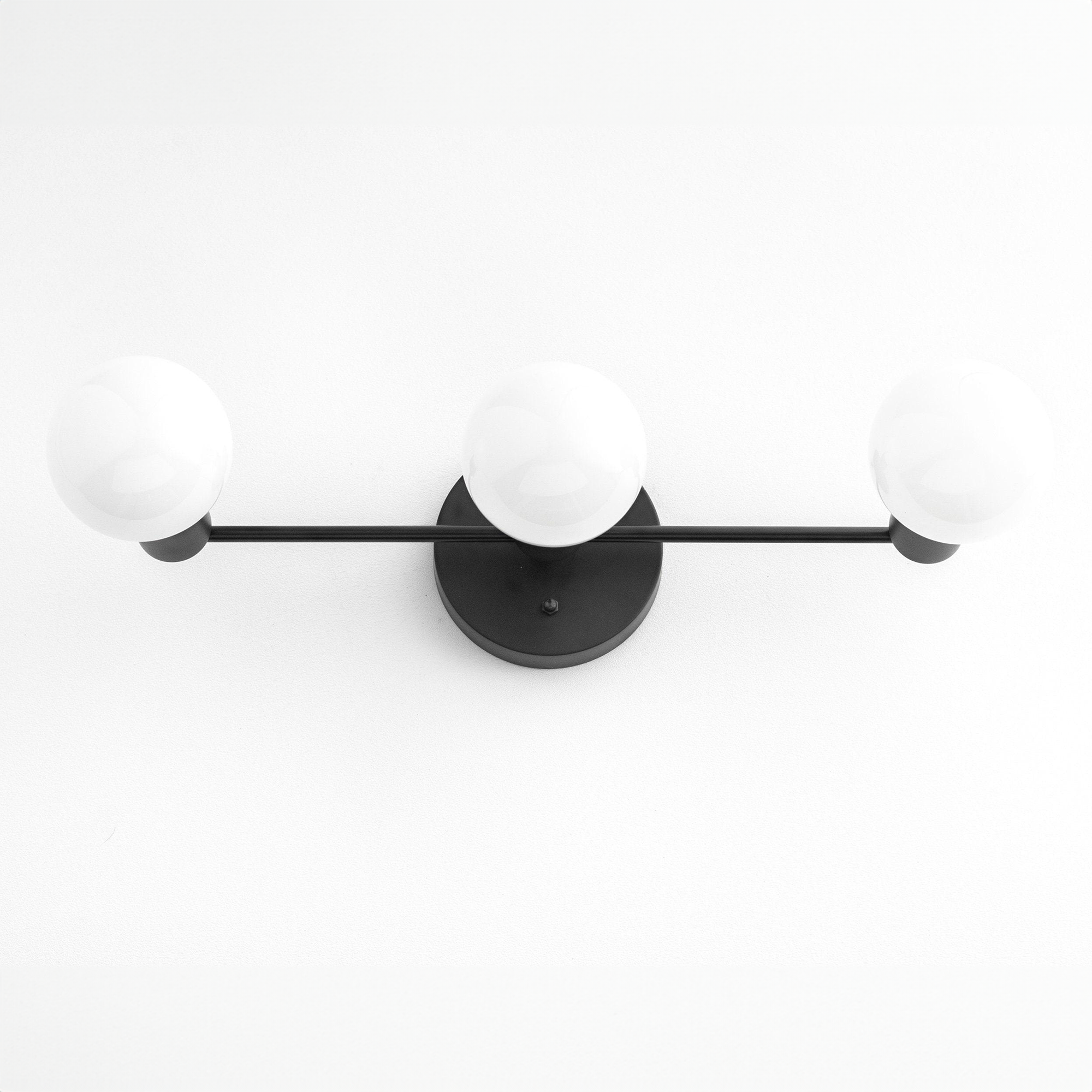 Mid-century modern 3-bulb black vanity light with round white glass shades and matte black metal frame. - VANITY LIGHT MODEL NO. 0518