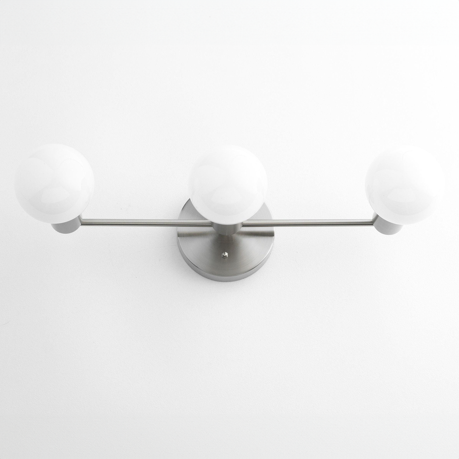 Mid-century modern three-bulb vanity light with brushed nickel finish and round white glass shades. - VANITY LIGHT MODEL NO. 0518