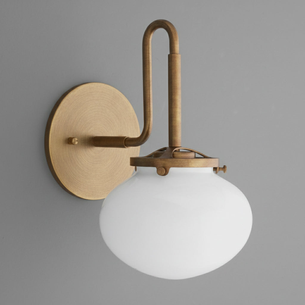 Wall sconce with brushed brass finish, curved arm, and frosted white glass globe shade. - SCONCE MODEL NO. 9452