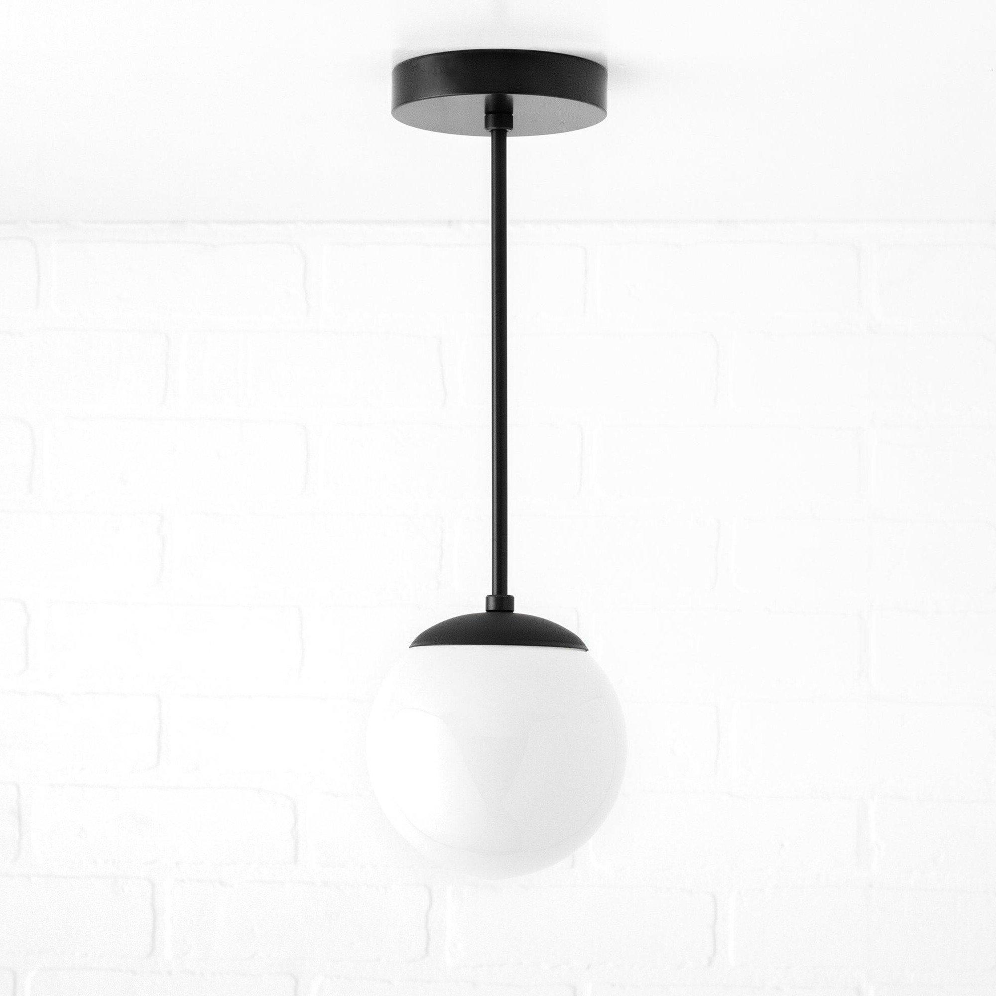 Mid-century modern pendant light with matte black canopy and white globe shade. - PENDANT MODEL NO. 7056