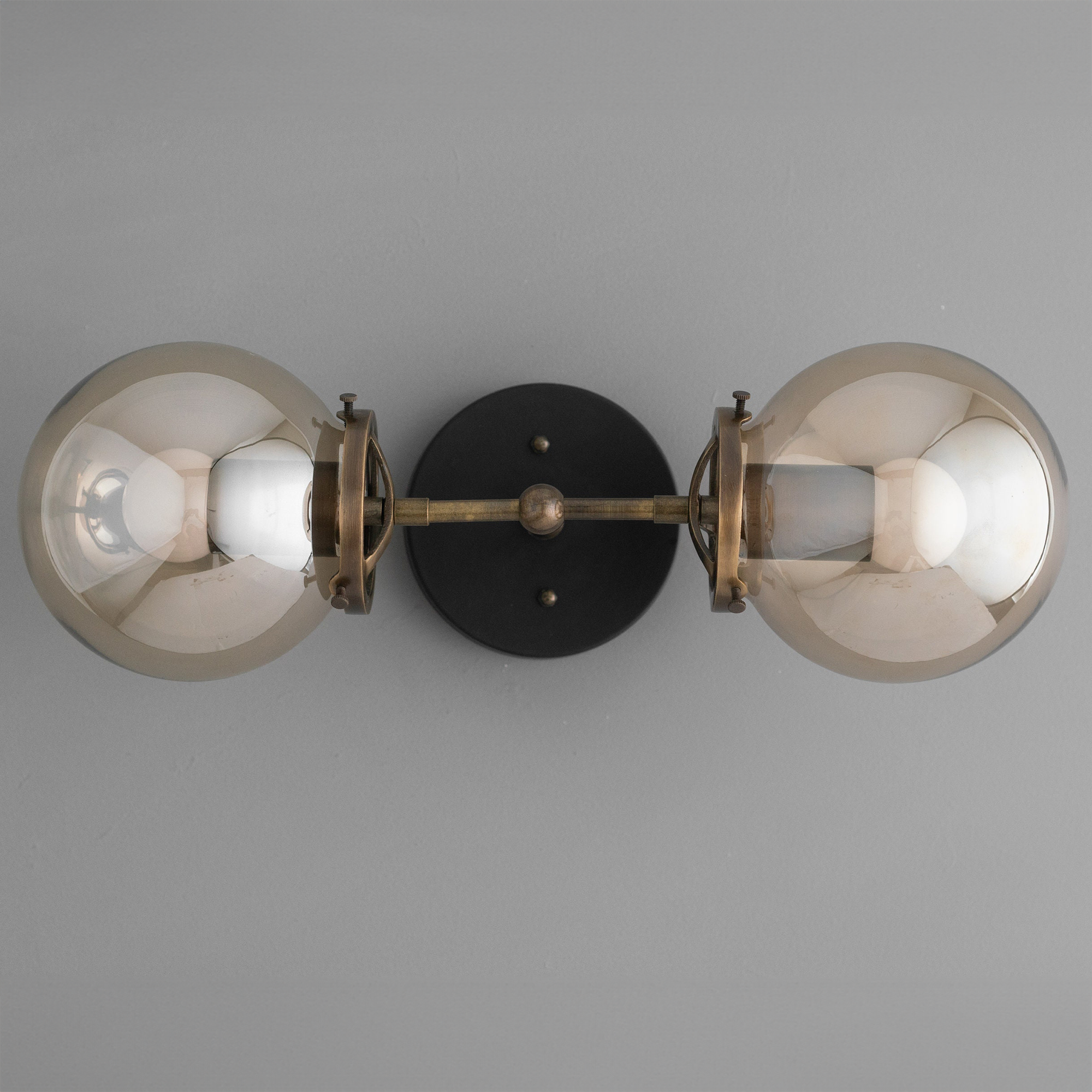 Mid-century modern vanity light with two smoked glass globe bulbs and black antique brass metal fixture. - VANITY LIGHT MODEL NO. 8983