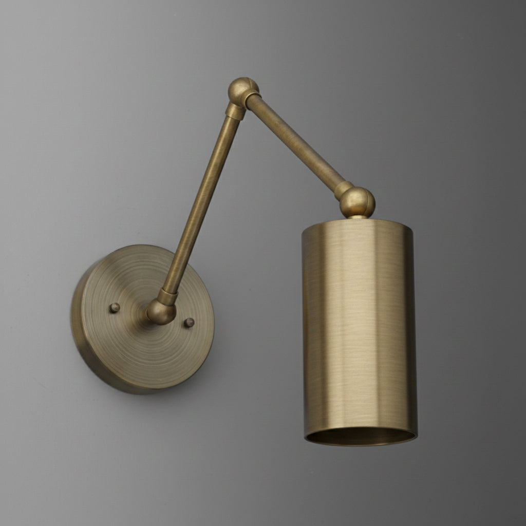 Adjustable wall sconce with a single cylindrical brass shade and matching round brass wall mount. - SCONCE MODEL NO. 0357