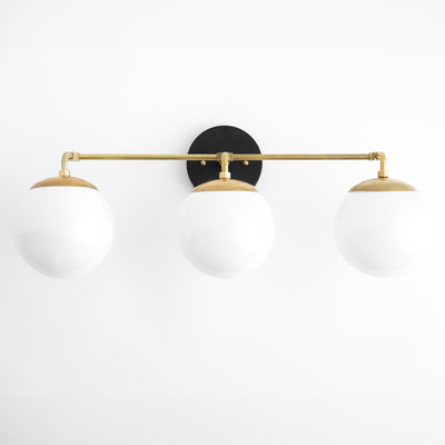 Mid-century modern vanity light with three white glass globes and a black and raw brass finish. - VANITY LIGHT MODEL NO. 9319