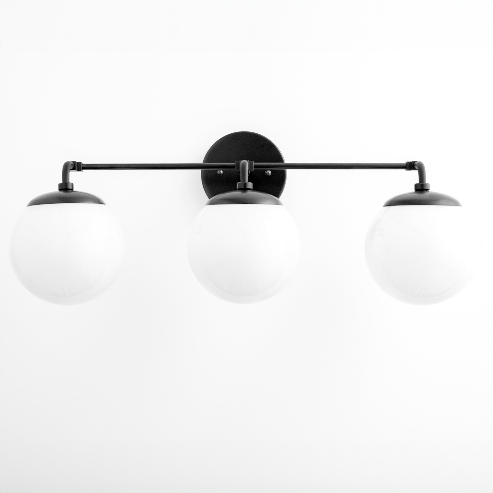 Black modern vanity light with three white globe shades on a horizontal bar. - VANITY LIGHT MODEL NO. 9319