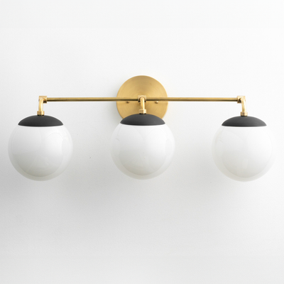 Mid-century modern vanity light with three white globe bulbs and matte black accents on a brushed gold horizontal bar. - VANITY LIGHT MODEL NO. 9319