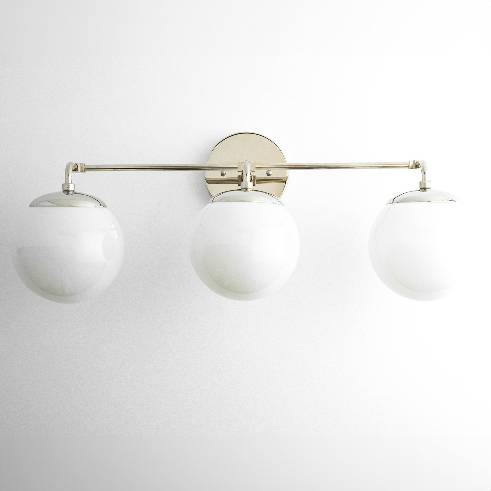 Mid-century modern vanity light with three white glass globe shades and a satin nickel horizontal bar. - VANITY LIGHT MODEL NO. 9319