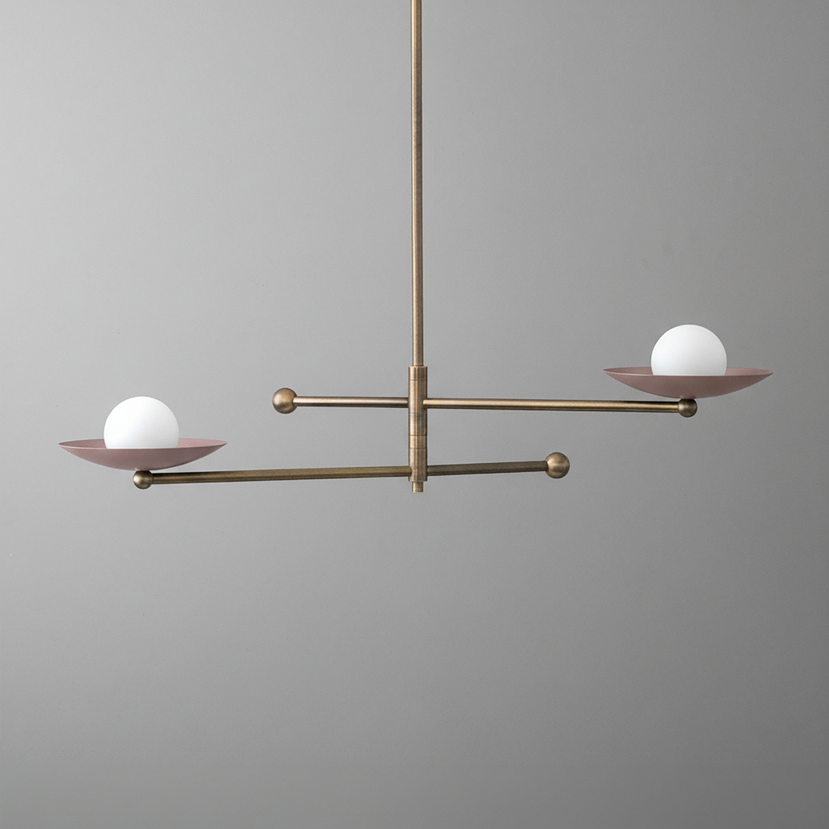 Antique brass chandelier with two mauve metal arms, each holding a white globe light. - CHANDELIER MODEL NO. 2933
