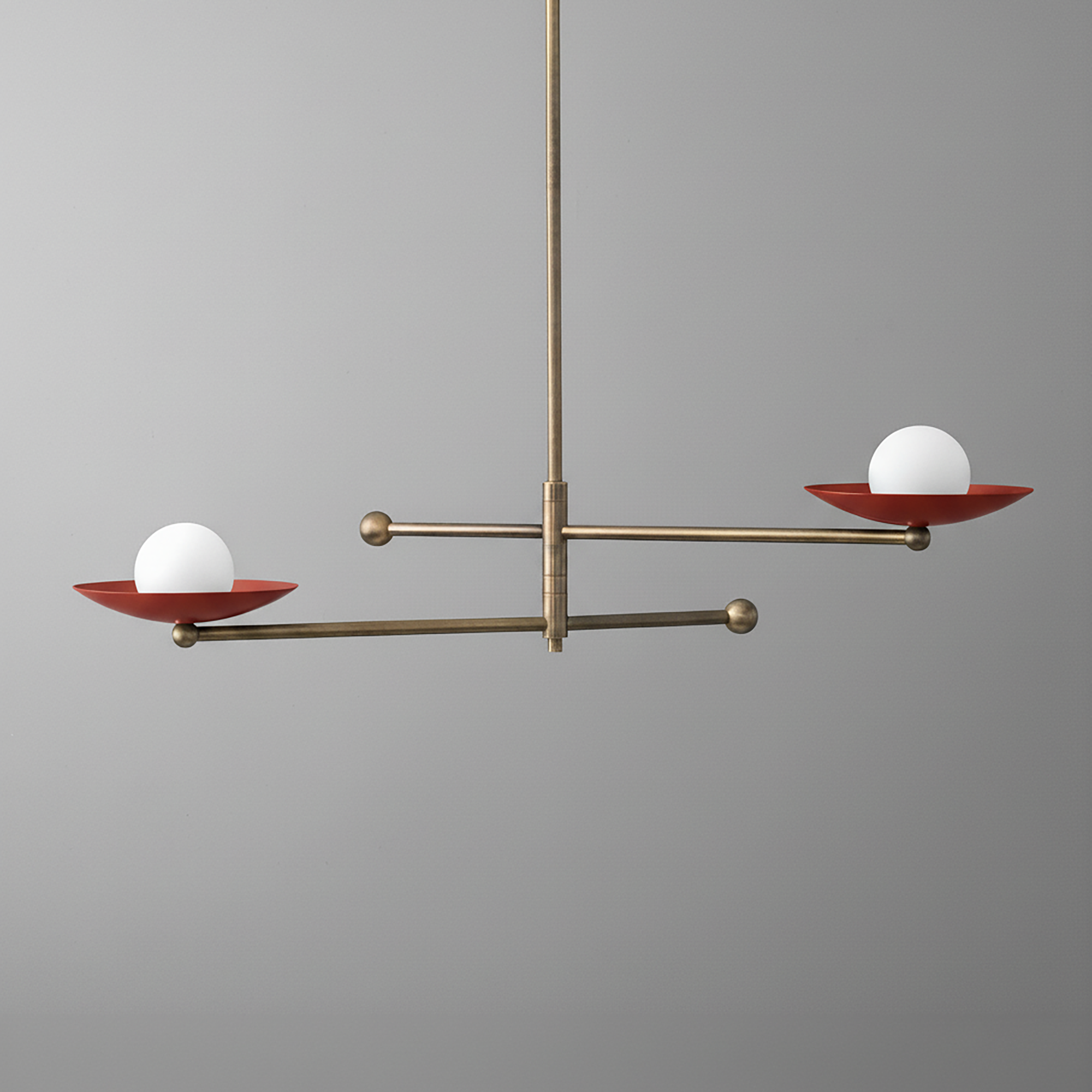 Mid-century modern chandelier with antique brass finish, two horizontal arms holding red disc shades and white globe bulbs. - CHANDELIER MODEL NO. 2933