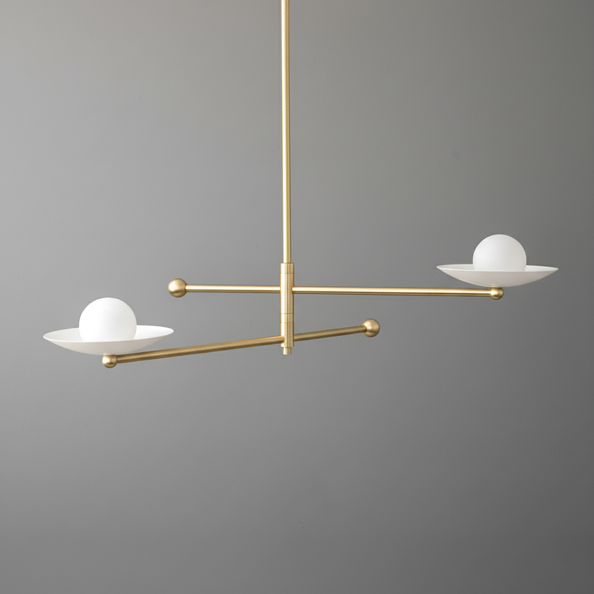 Mid-century modern chandelier with two white globe lights on matte brass swivel arms against gray background. - CHANDELIER MODEL NO. 2933