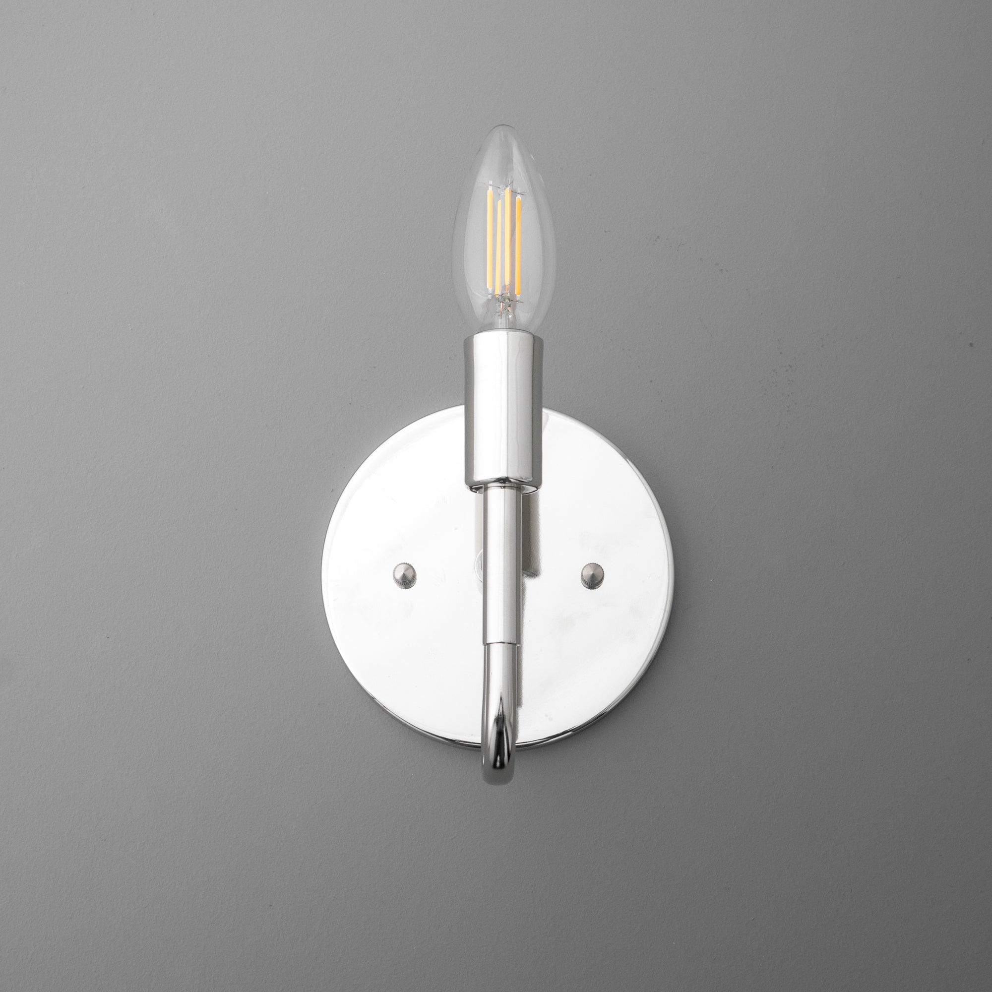 Modern silver metal wall sconce with exposed LED filament bulb and circular backplate. - SCONCE MODEL NO. 1100