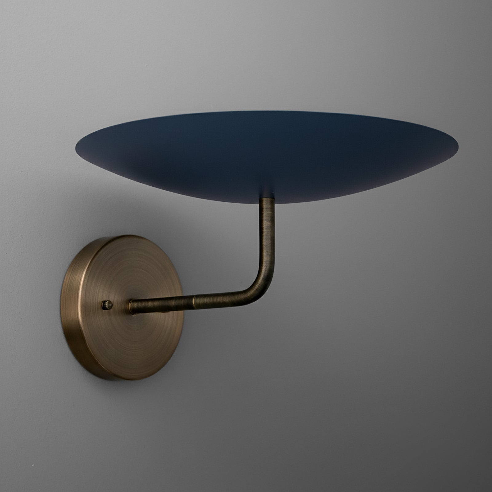 Wall sconce with round brass base and an upward-facing, flat, dark blue metal shade. - SCONCE MODEL NO. 1504